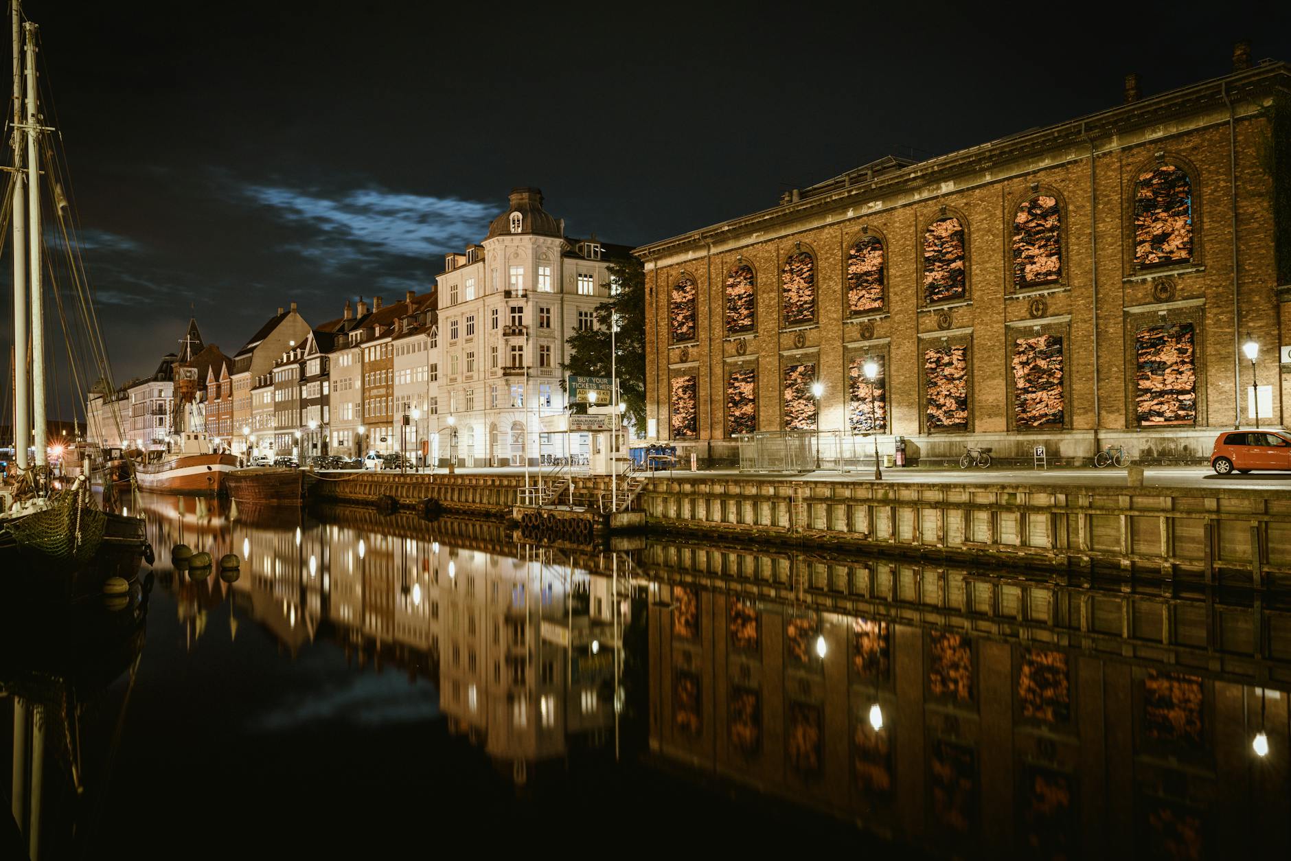 Copenhagen canal buildings at night for late-night logistics planning.