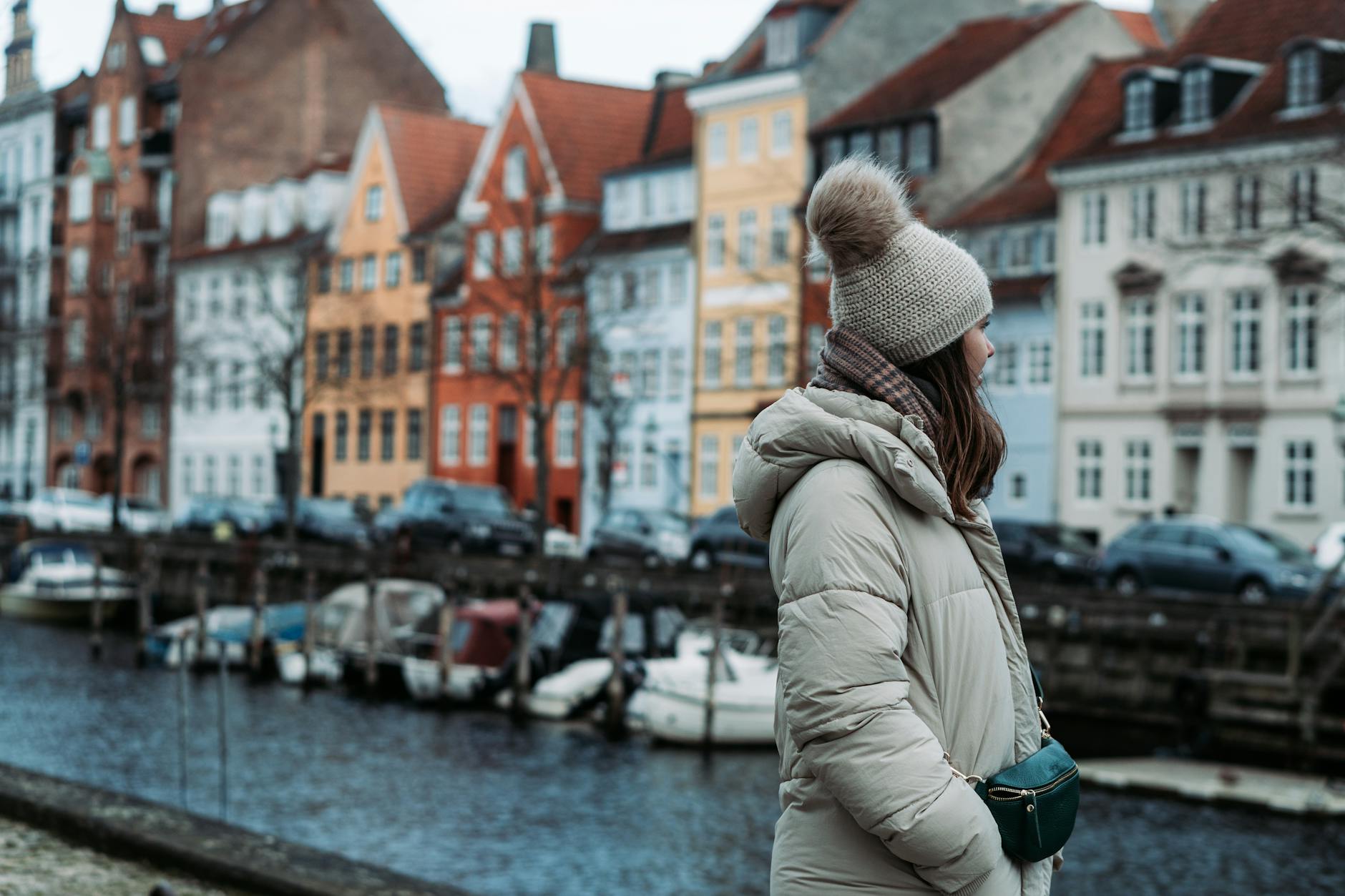 Solo traveler by Copenhagen canal buildings for independent trip planning.