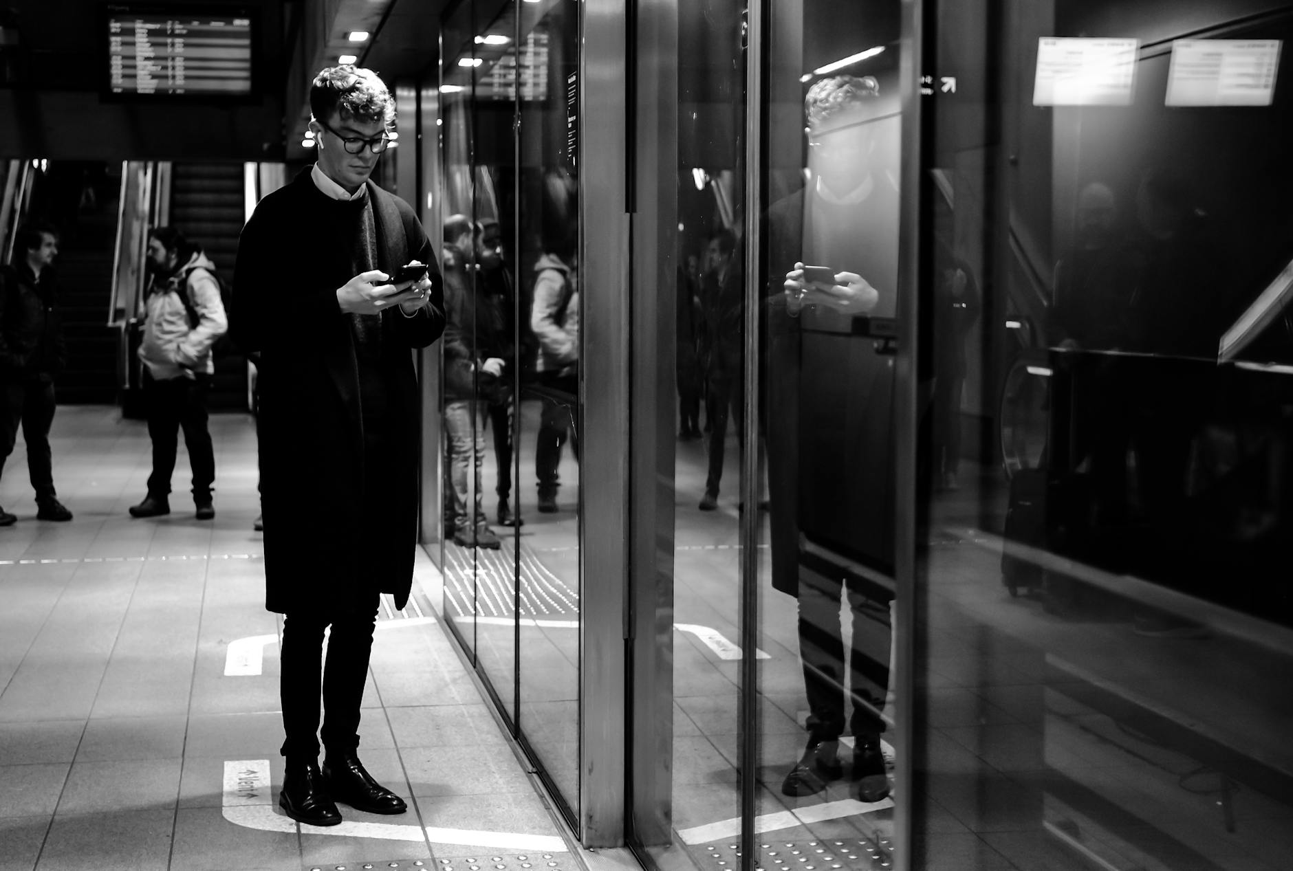 Traveler with phone at Copenhagen metro for solo transit planning.