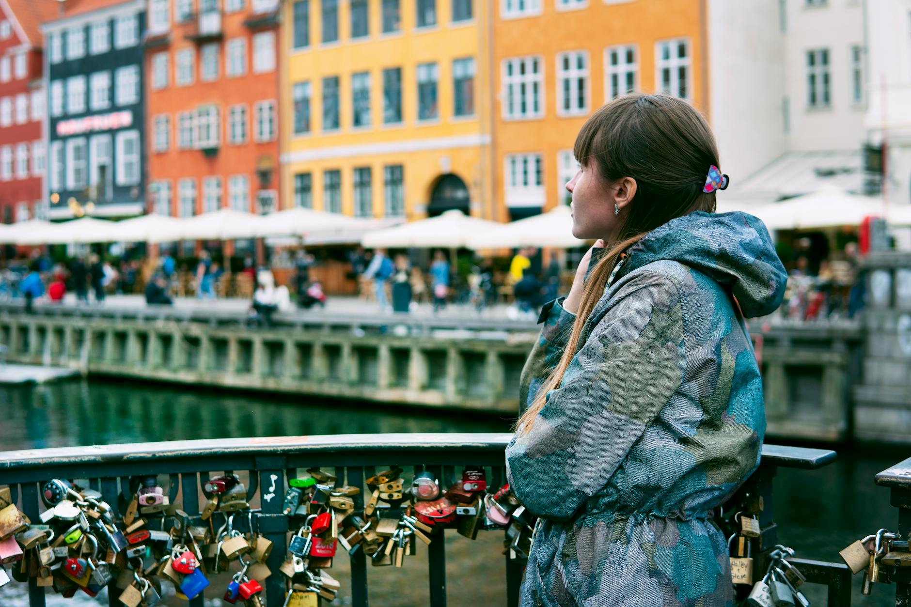 Woman looking toward Nyhavn for Copenhagen travel report planning.