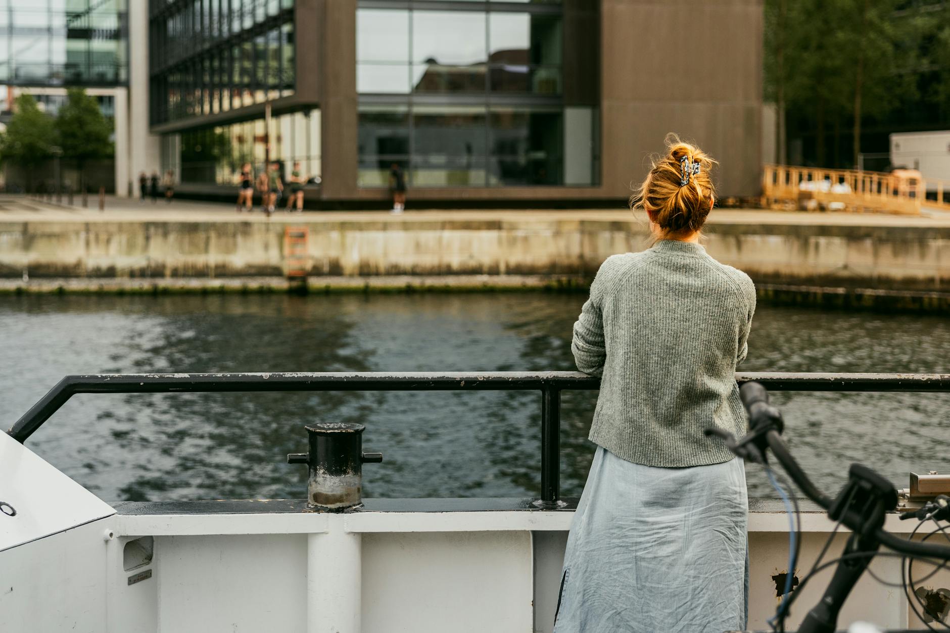 Woman on Copenhagen waterfront for rest and weather planning.
