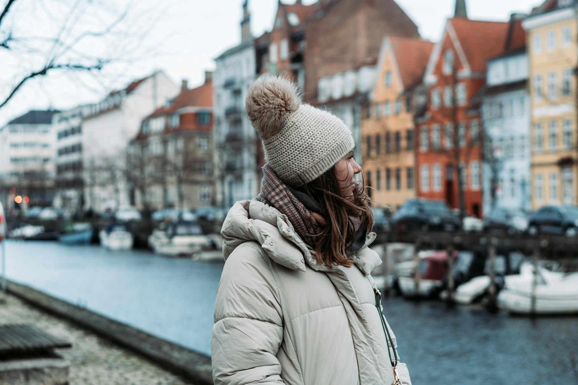 Woman by a Copenhagen canal for short-term travel planning.