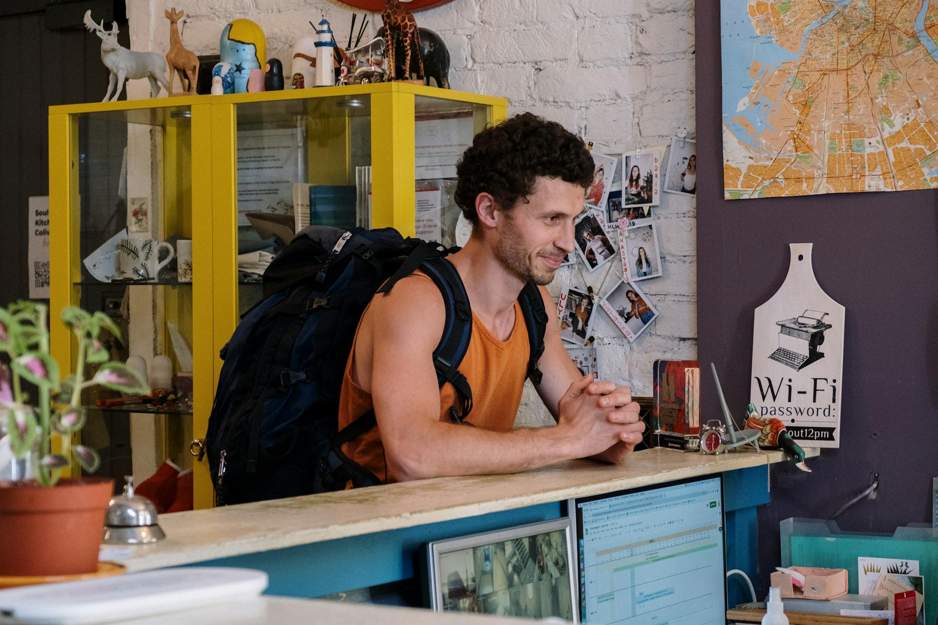 A backpacker checking into a cozy hostel with vibrant decor and friendly atmosphere.