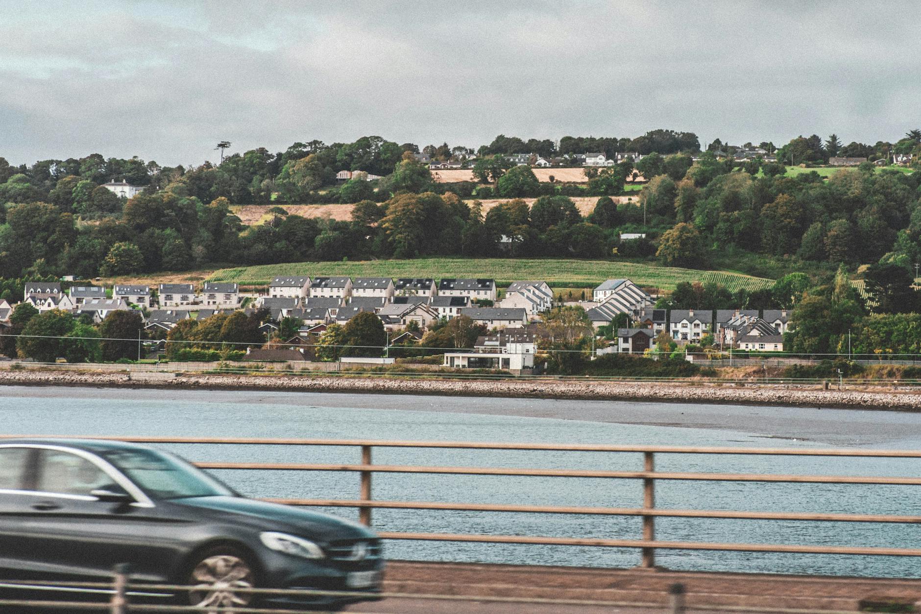 Charming village by the water in Cork, Ireland with lush greenery.