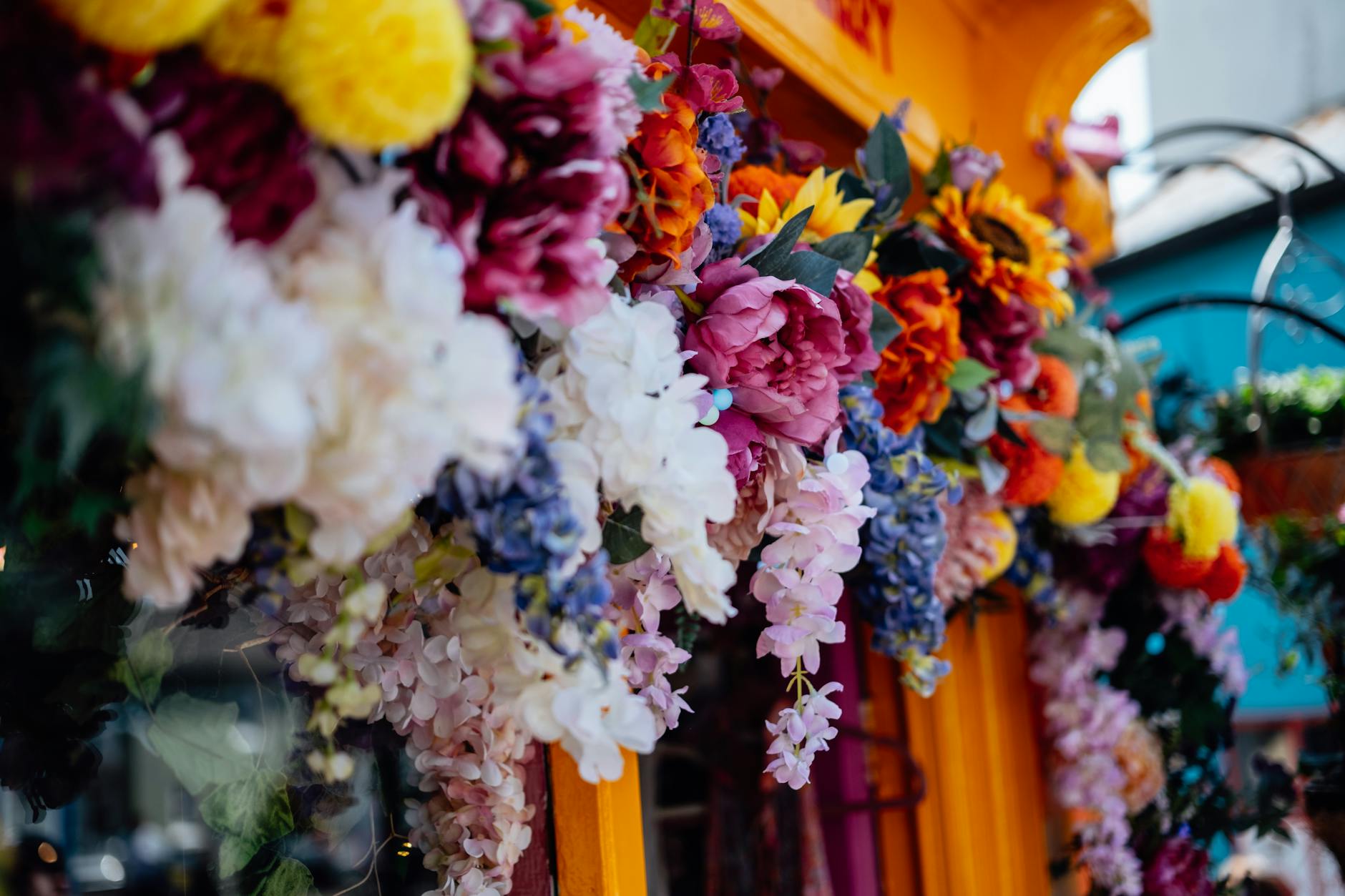 Colorful artificial flowers adorn a shopfront in Cork, capturing vibrant spring urban charm.