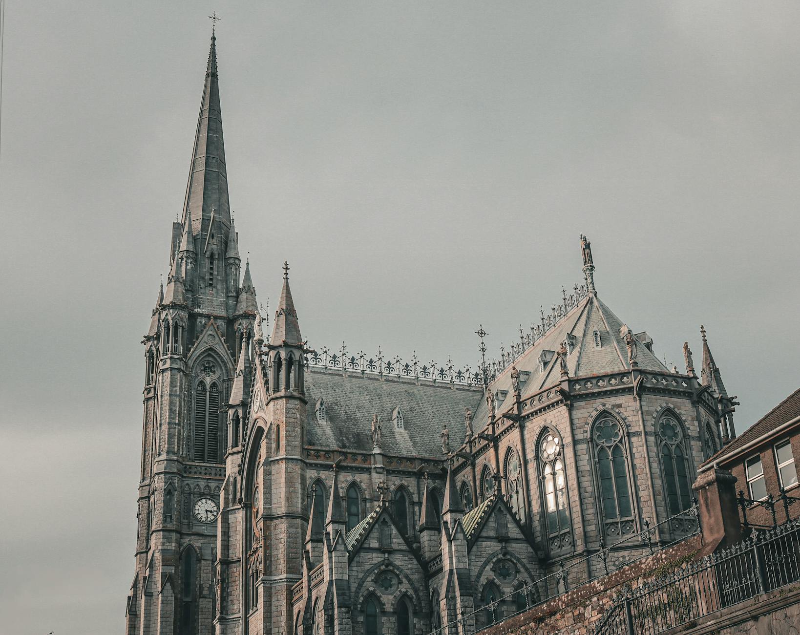 St. Colman's Cathedral with its Gothic architecture in Cobh, Ireland, under a muted sky.