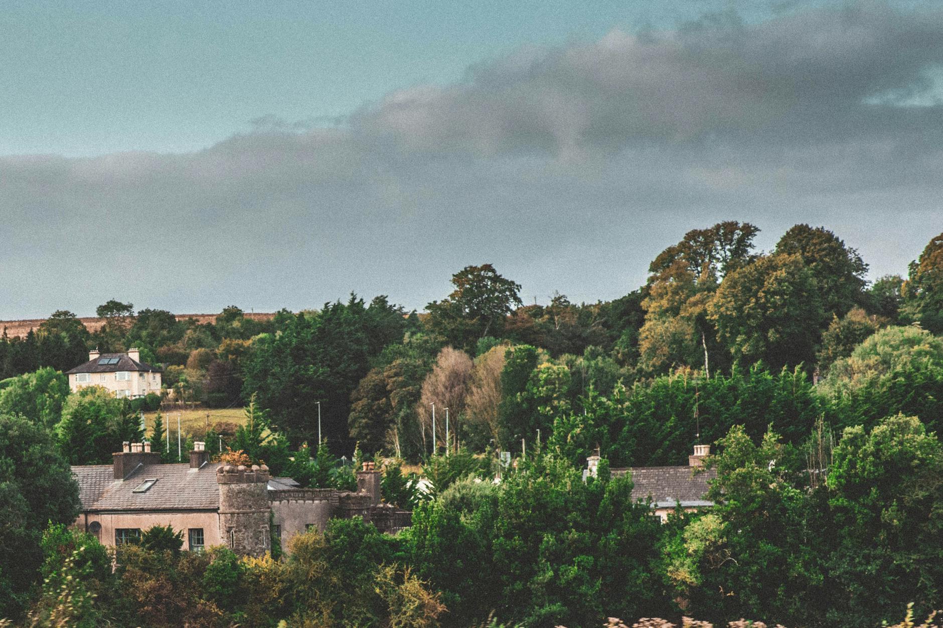 Picturesque view of historic buildings amidst lush greenery in Cork, Ireland.