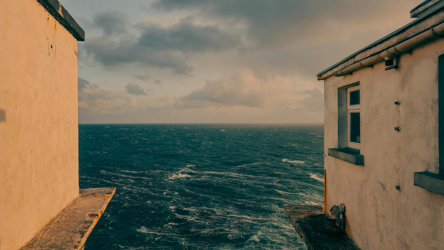 Captivating ocean view between two seaside buildings in Goleen, Ireland.