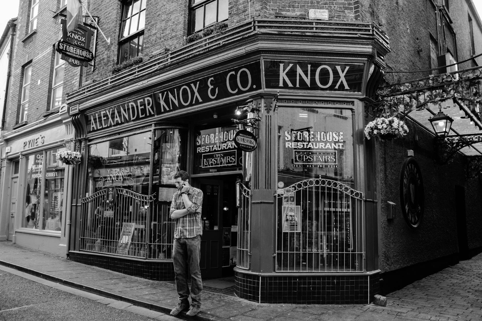 Historic pub on street corner, featuring vintage architecture in black and white.