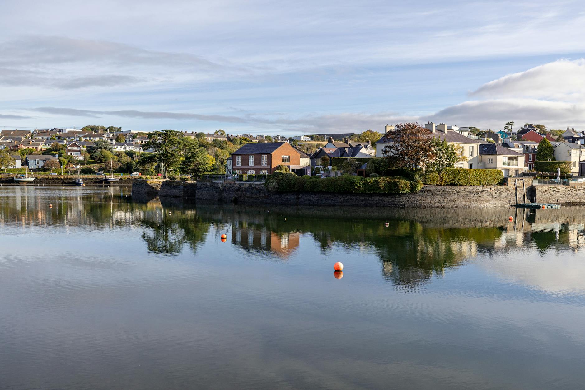 Charming houses reflect in the calm waters of Kinsale, County Cork, Ireland.