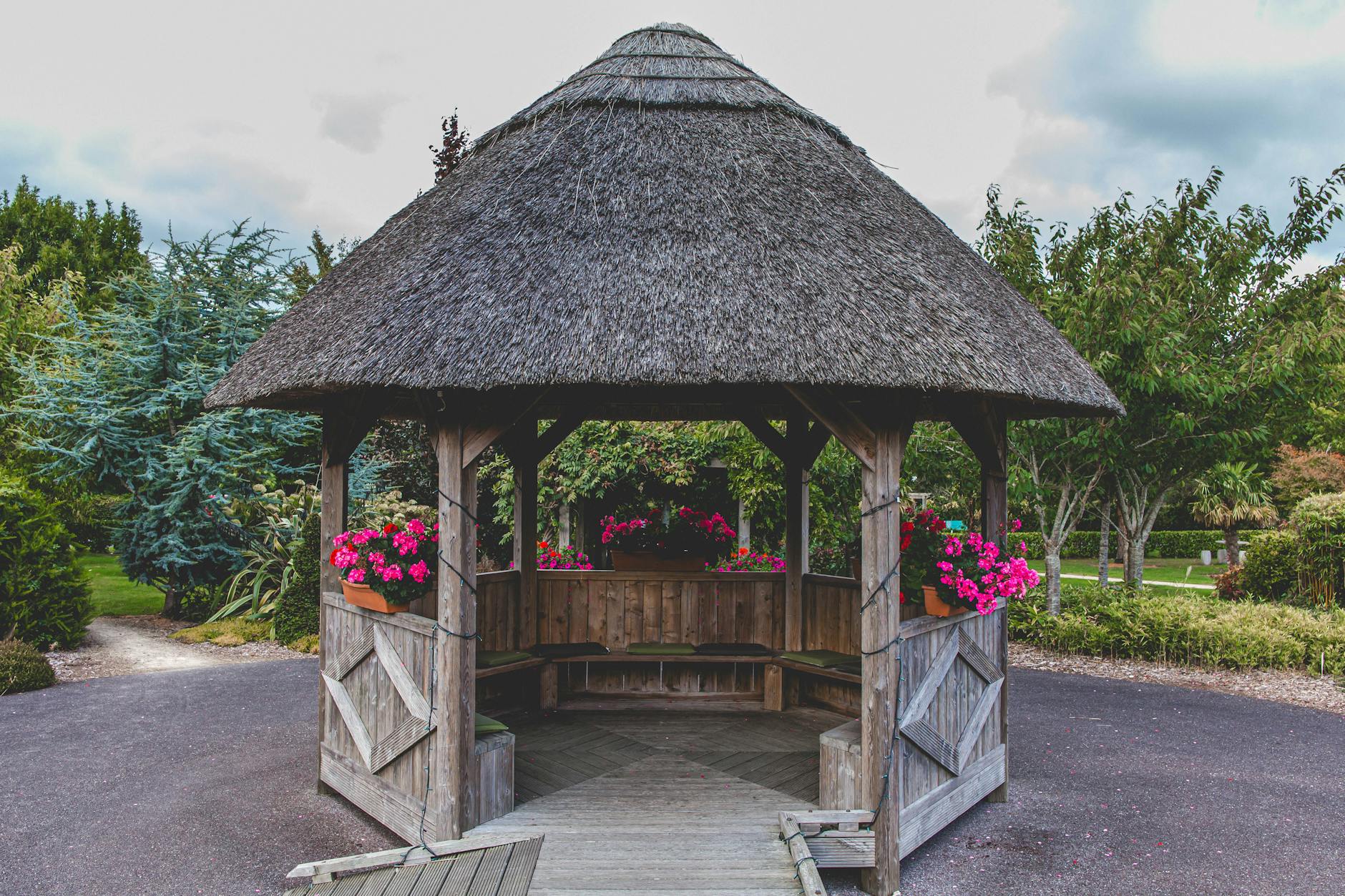 Rustic wooden gazebo with floral accents in a serene Irish garden. Ideal for relaxation and nature lovers.