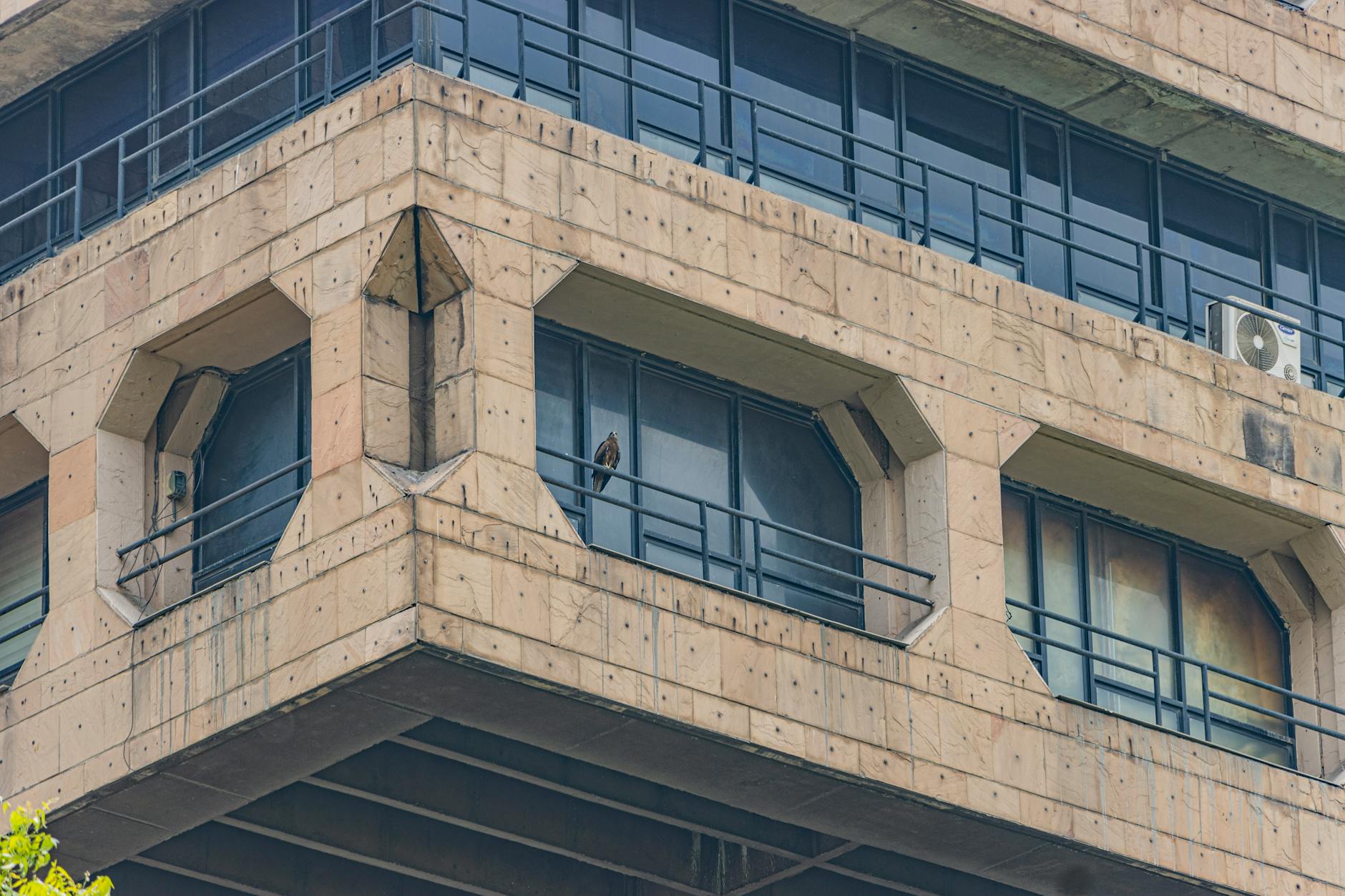Brutalist building facade in New Delhi for academic conference travel report planning.
