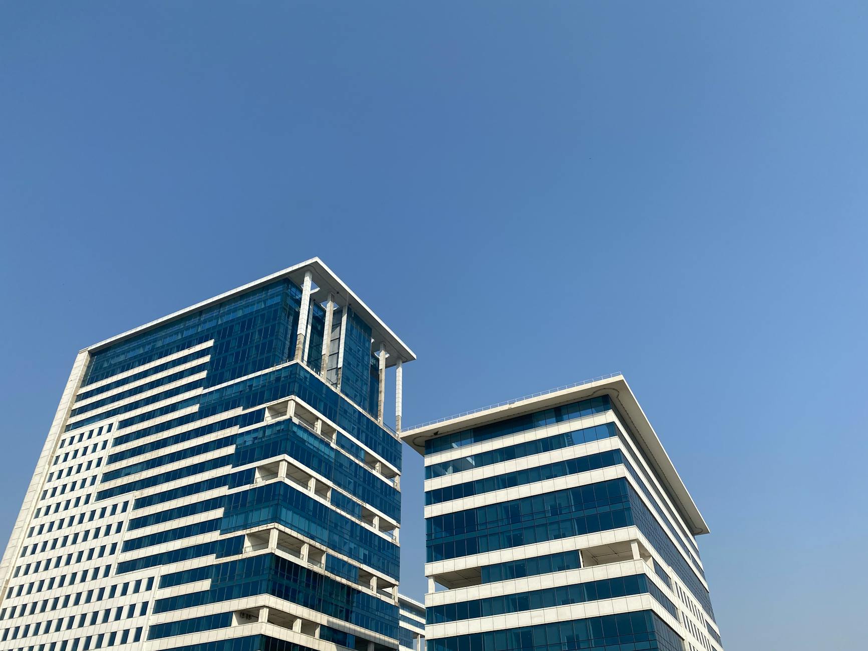 Modern Gurugram office buildings for Delhi business travel report planning.