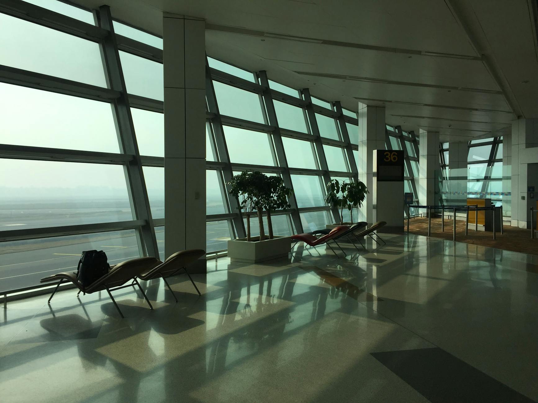 Sunlit New Delhi airport terminal seating for older traveler departure planning.