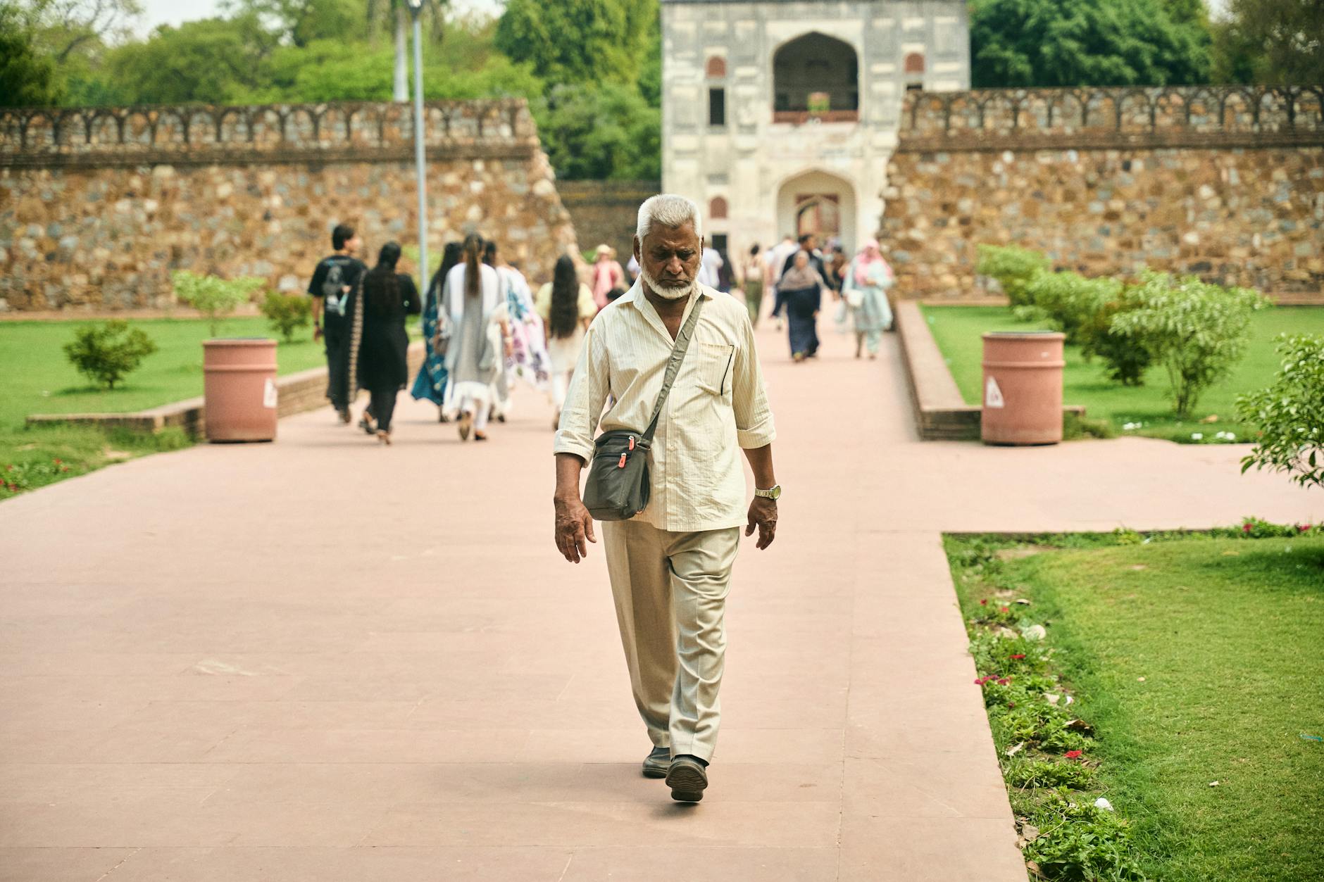 Older visitor walking in a historic Delhi garden for paced sightseeing planning.