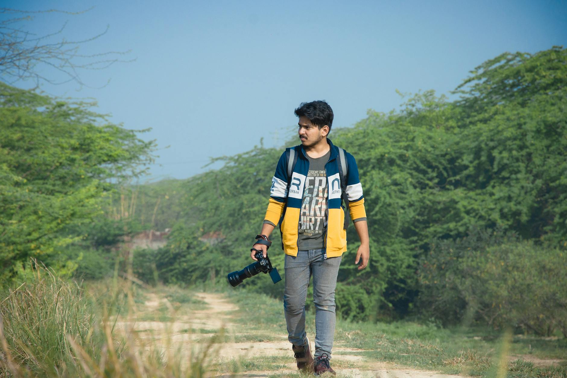 Solo traveler with camera walking through greenery in Delhi.