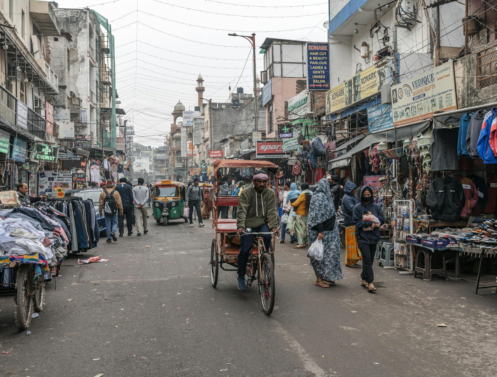 Busy New Delhi market street with rickshaw for solo route planning.