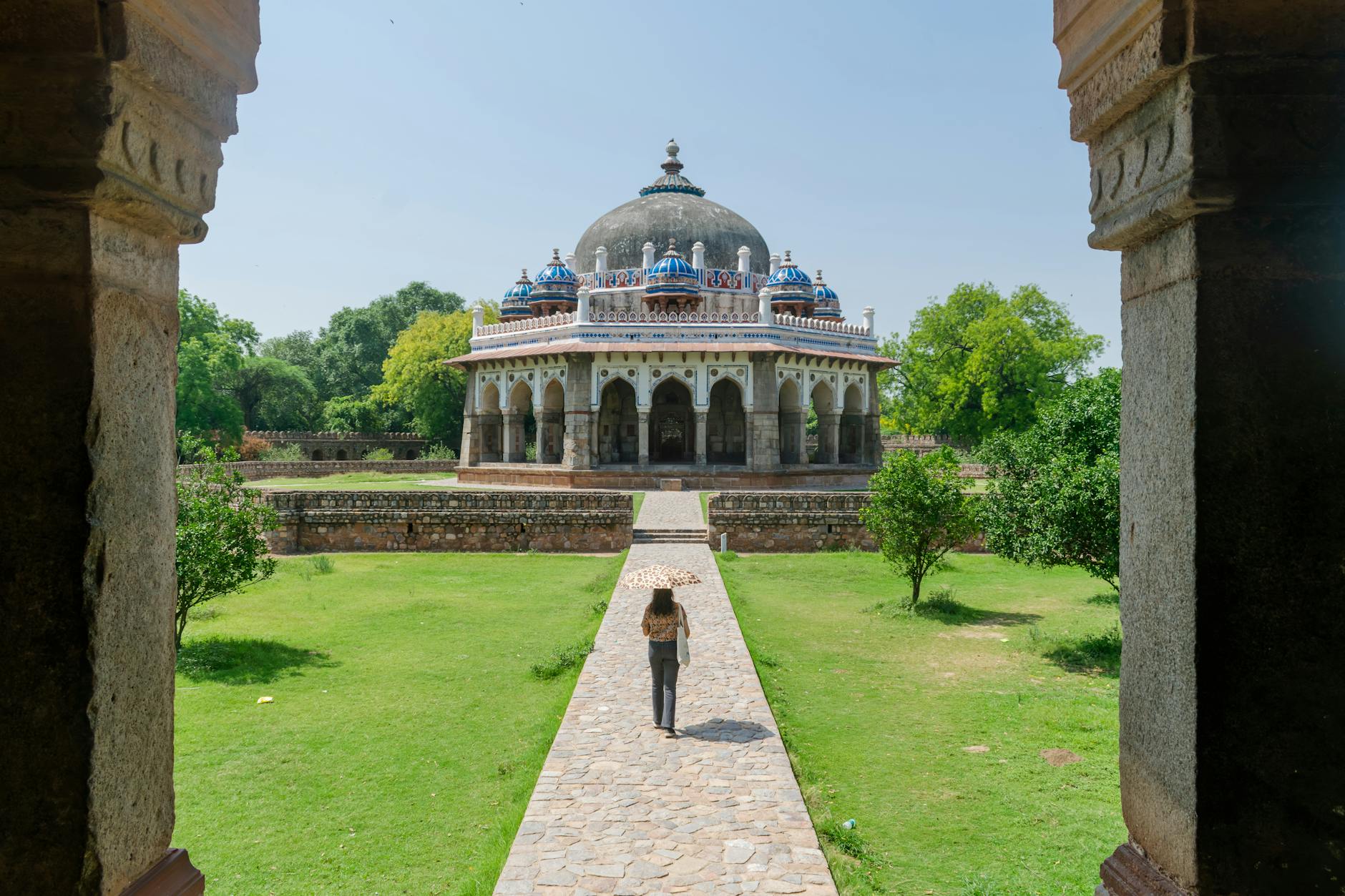 Woman walking toward Isa Khan's Tomb in New Delhi for independent route planning.