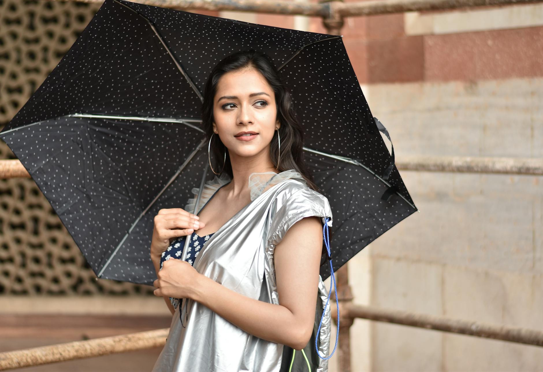 Woman with umbrella outdoors in New Delhi for health and weather planning.