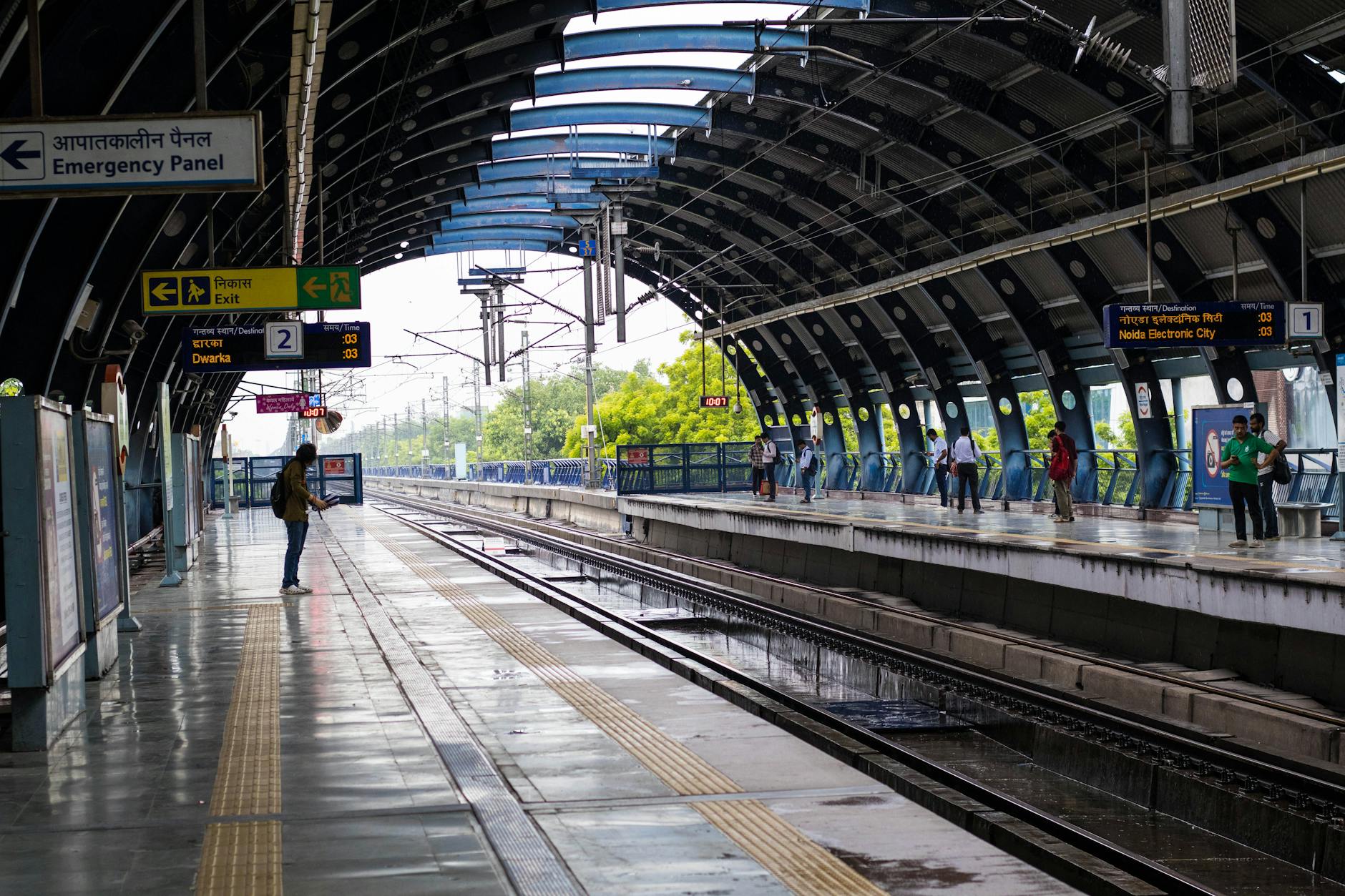 People waiting at a New Delhi metro station for woman traveler transport planning.