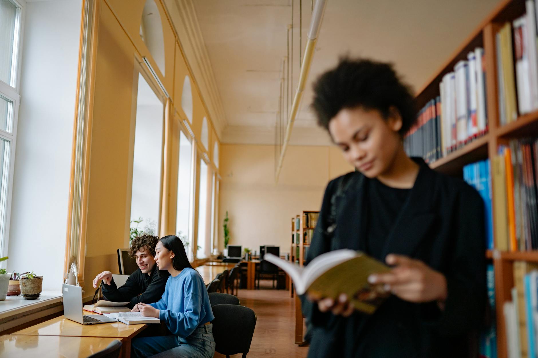 Students studying in a library for Helsinki conference preparation planning.