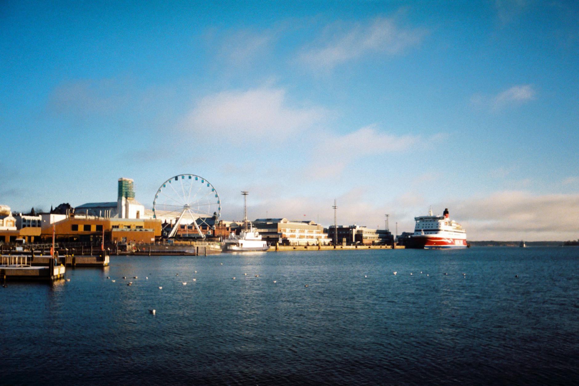 Helsinki harbor with ships and SkyWheel for budget travel report planning.