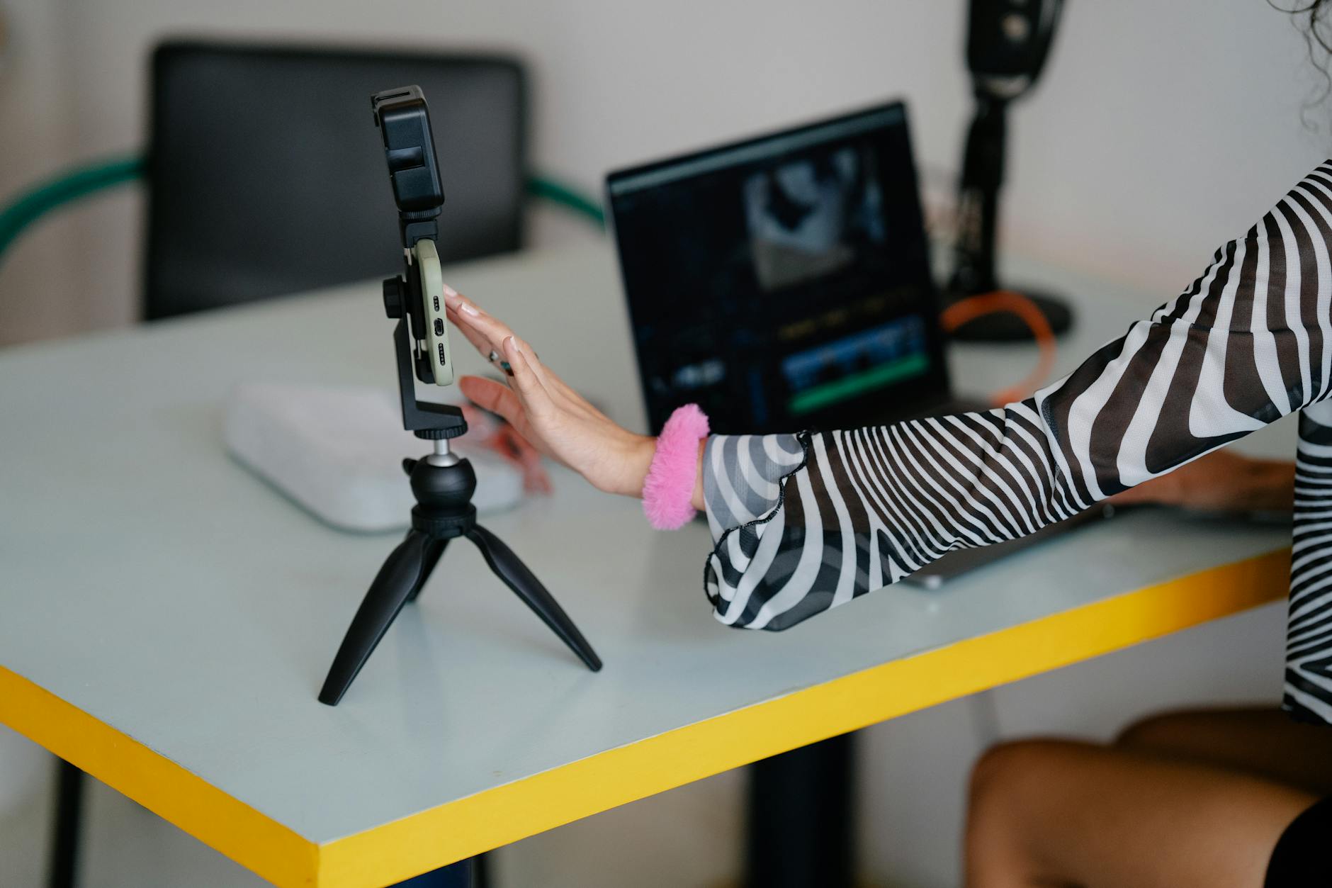 Creator adjusting smartphone tripod for Helsinki permission planning.