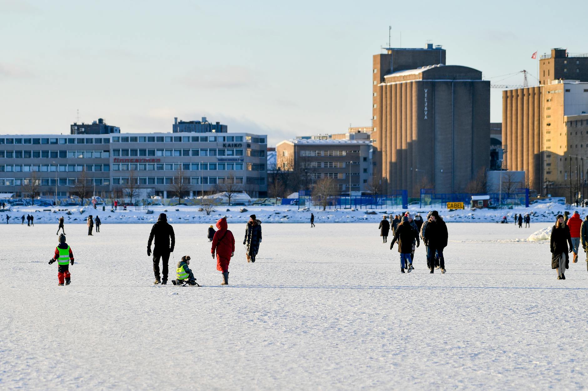 People on frozen sea near Helsinki for family travel weather planning.