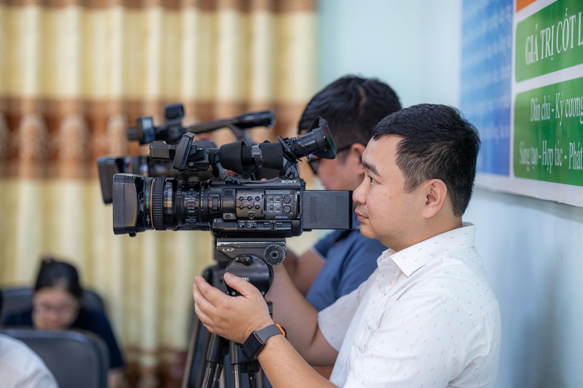 Cameraman filming an event for Helsinki journalist equipment planning.