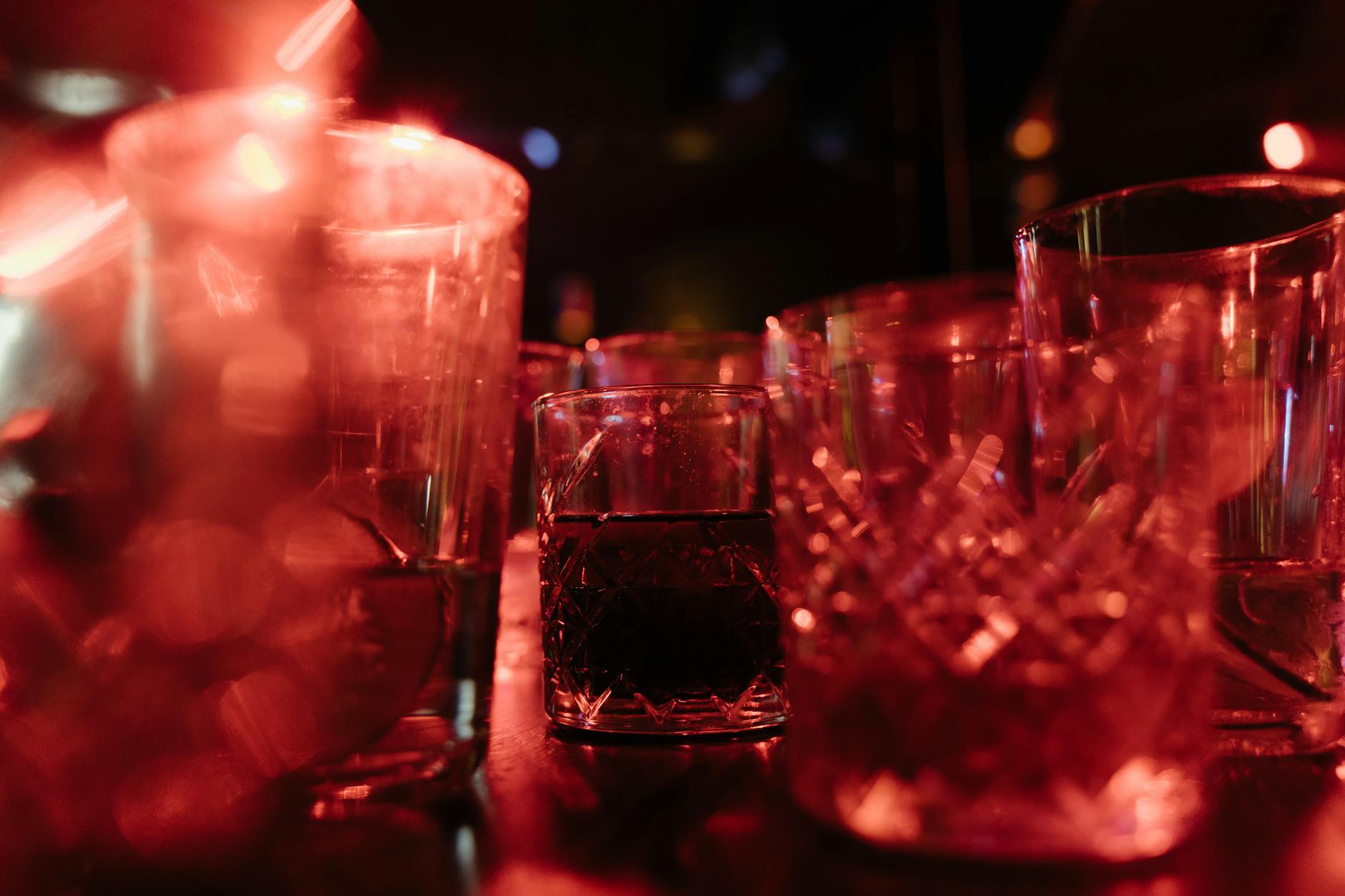 Red-lit bar glasses for Helsinki nightlife travel report planning.