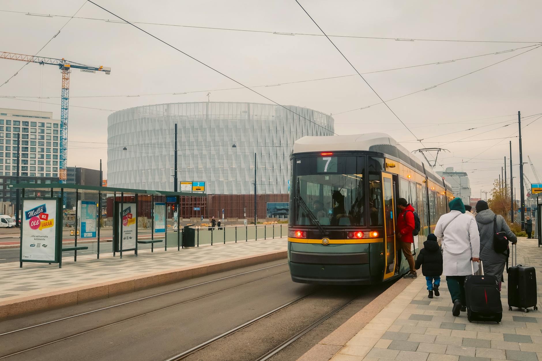 Passengers boarding a Helsinki winter tram for walking and access planning.