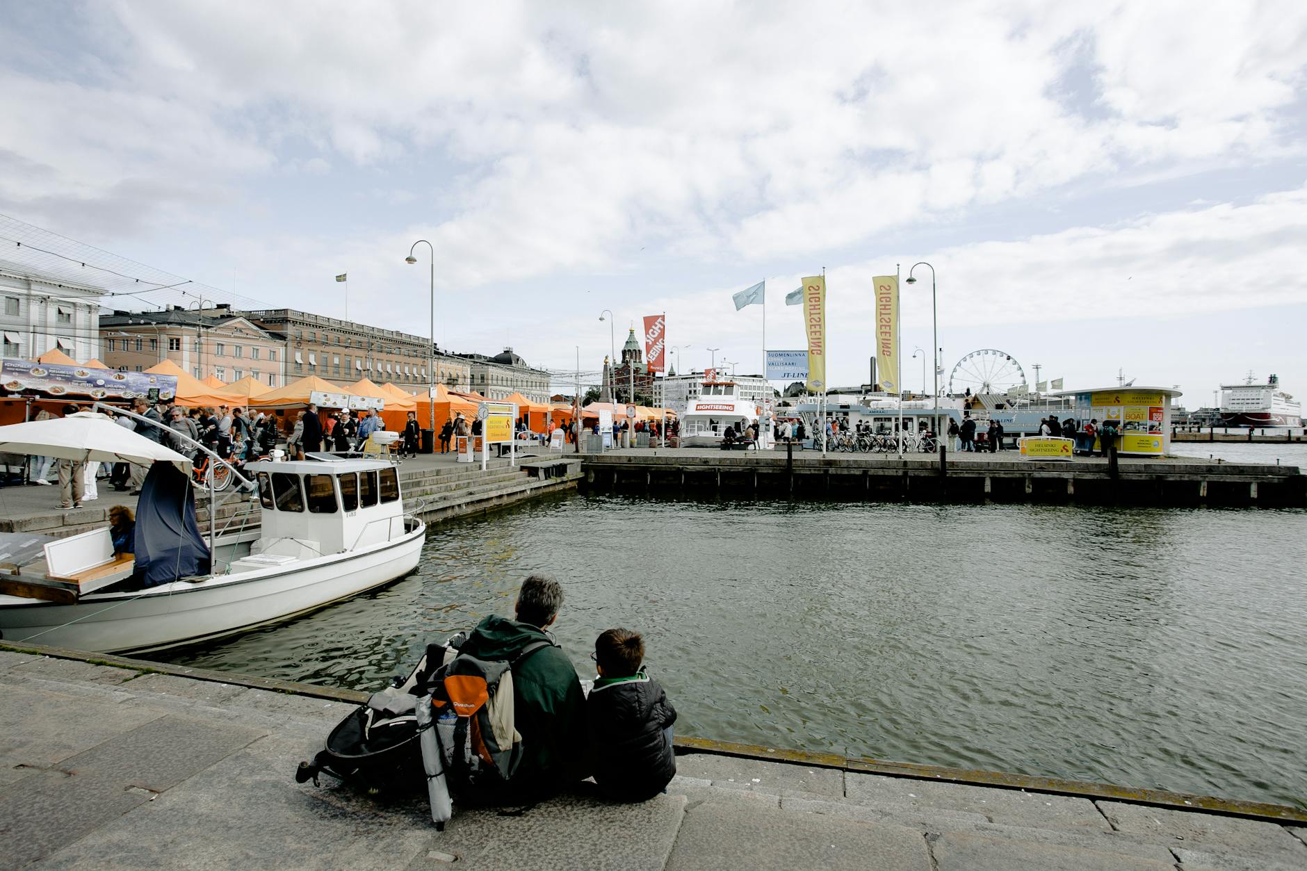 People sitting by a Helsinki waterfront for older traveler pacing planning.