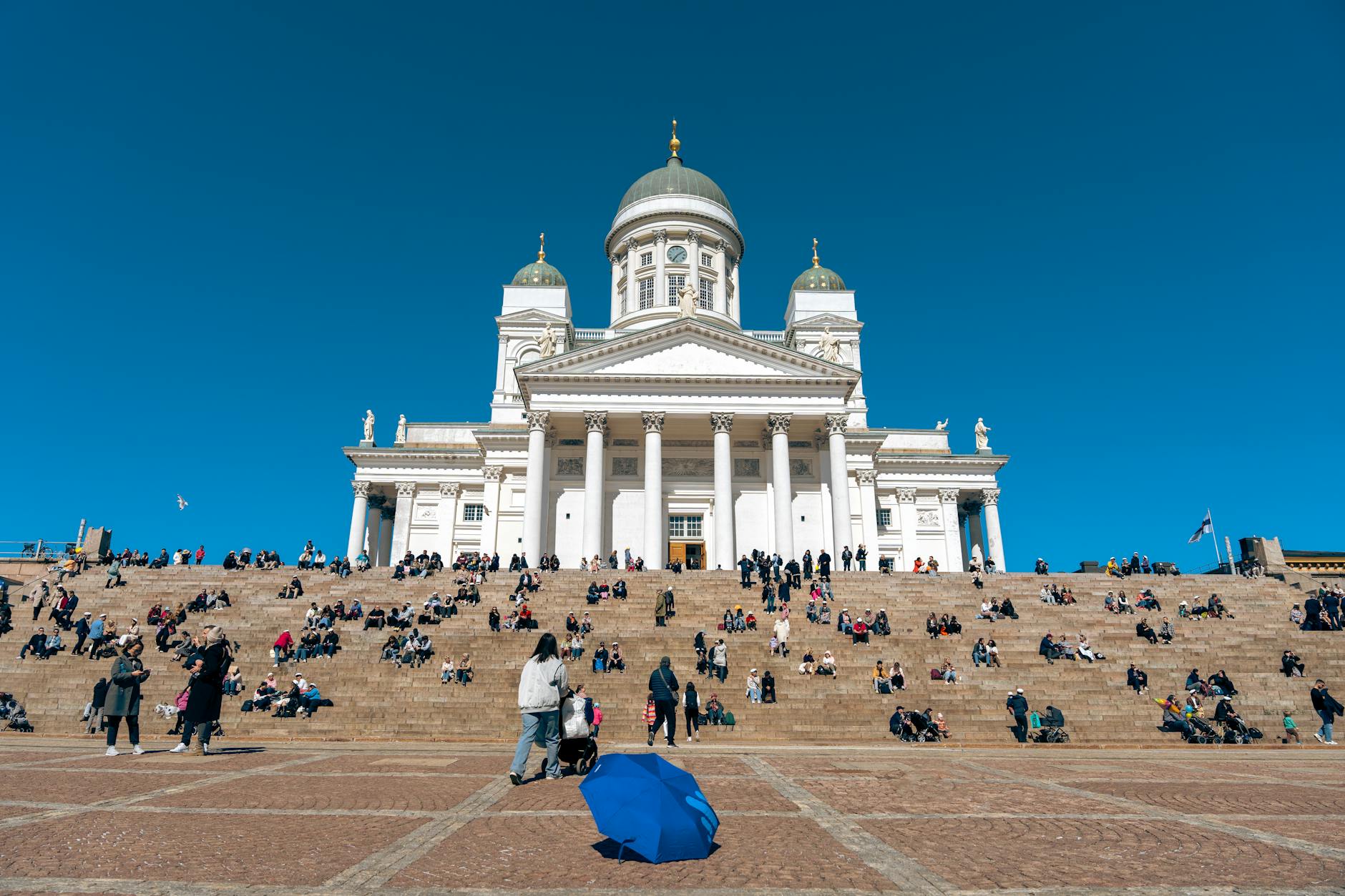 People on Helsinki Cathedral steps for pilgrimage pacing planning.