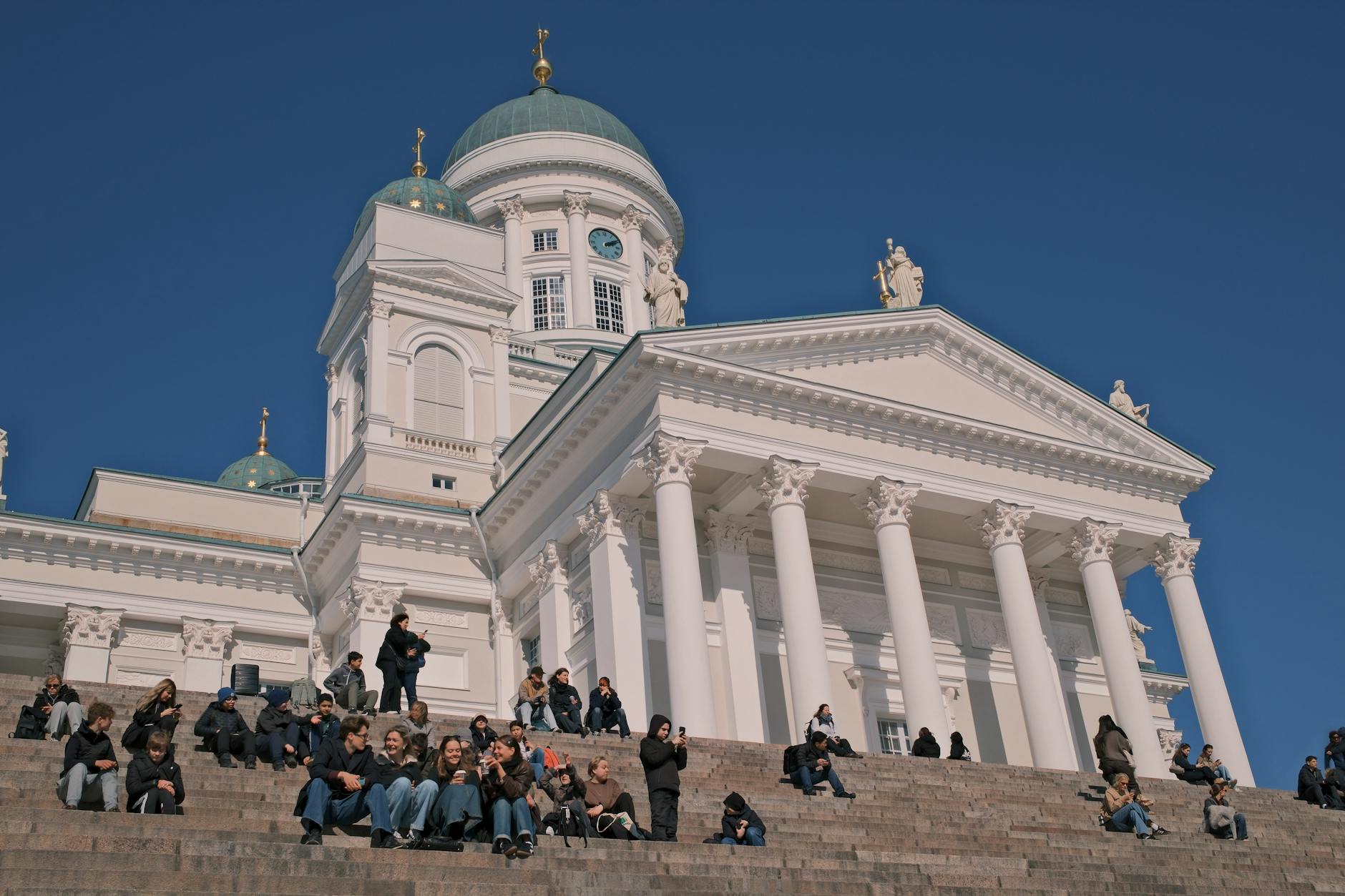 Visitors on Helsinki Cathedral steps for slow return-visit pacing.