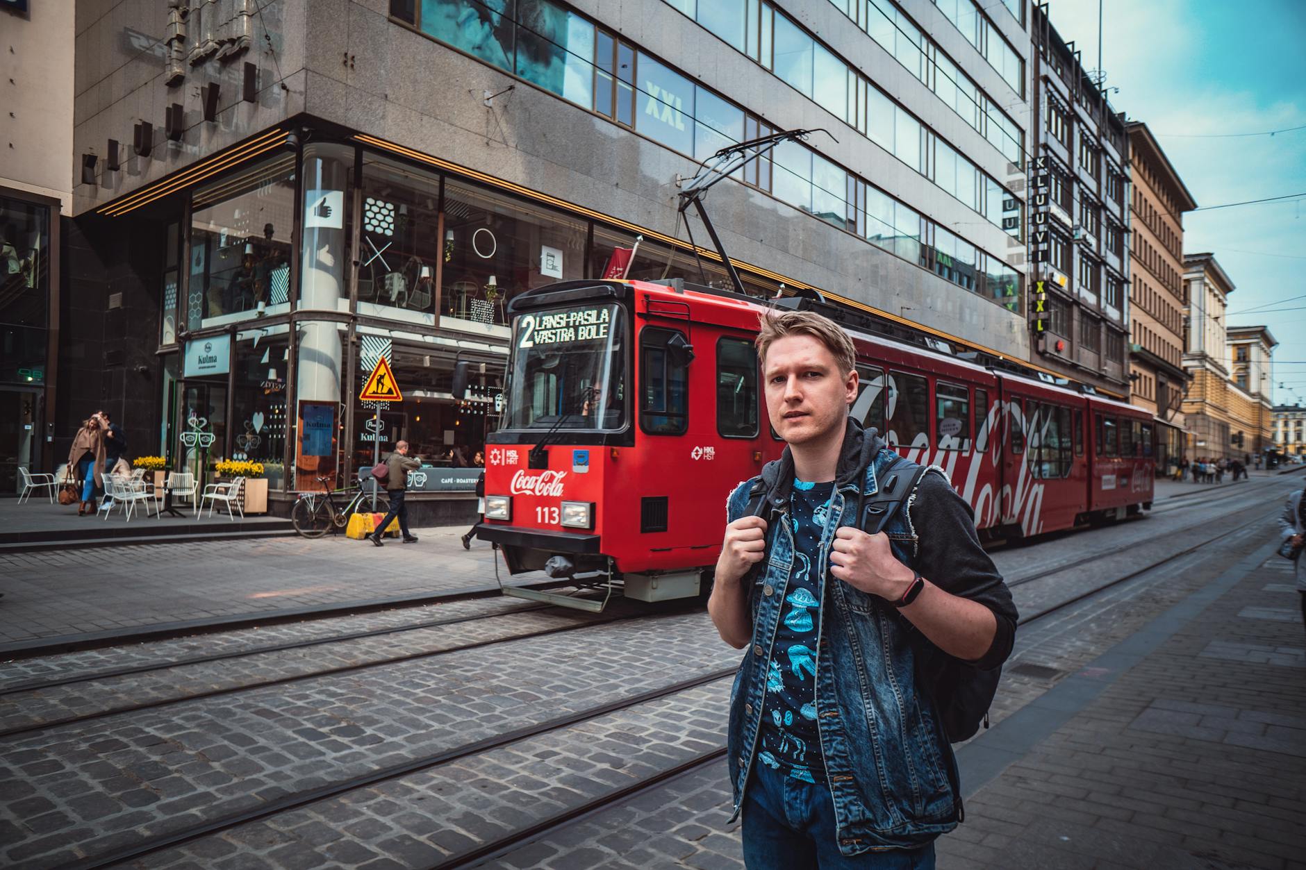 Traveler near a Helsinki tram for solo hotel-return planning.