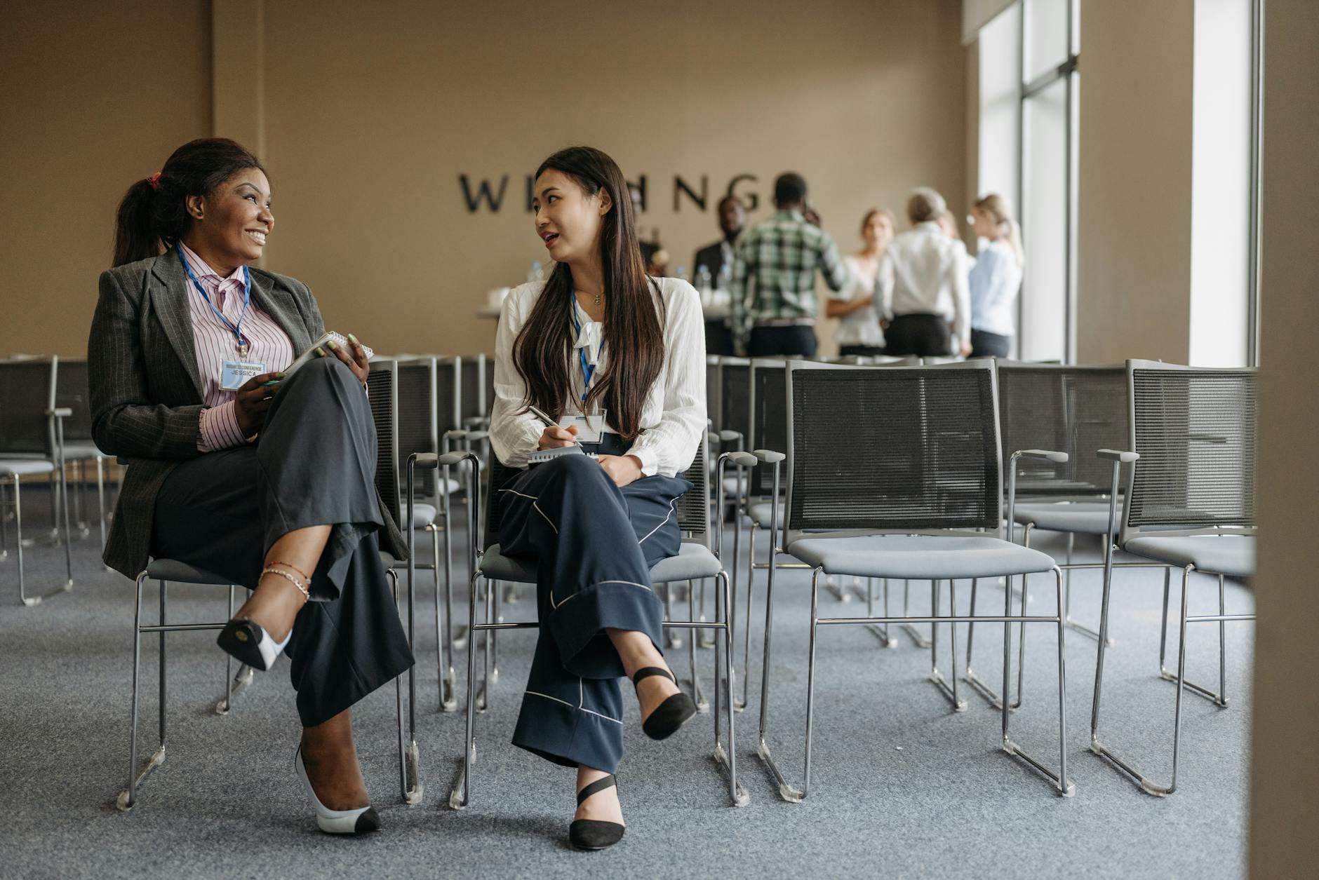 Professionals talking during a conference break for trade-show networking planning.