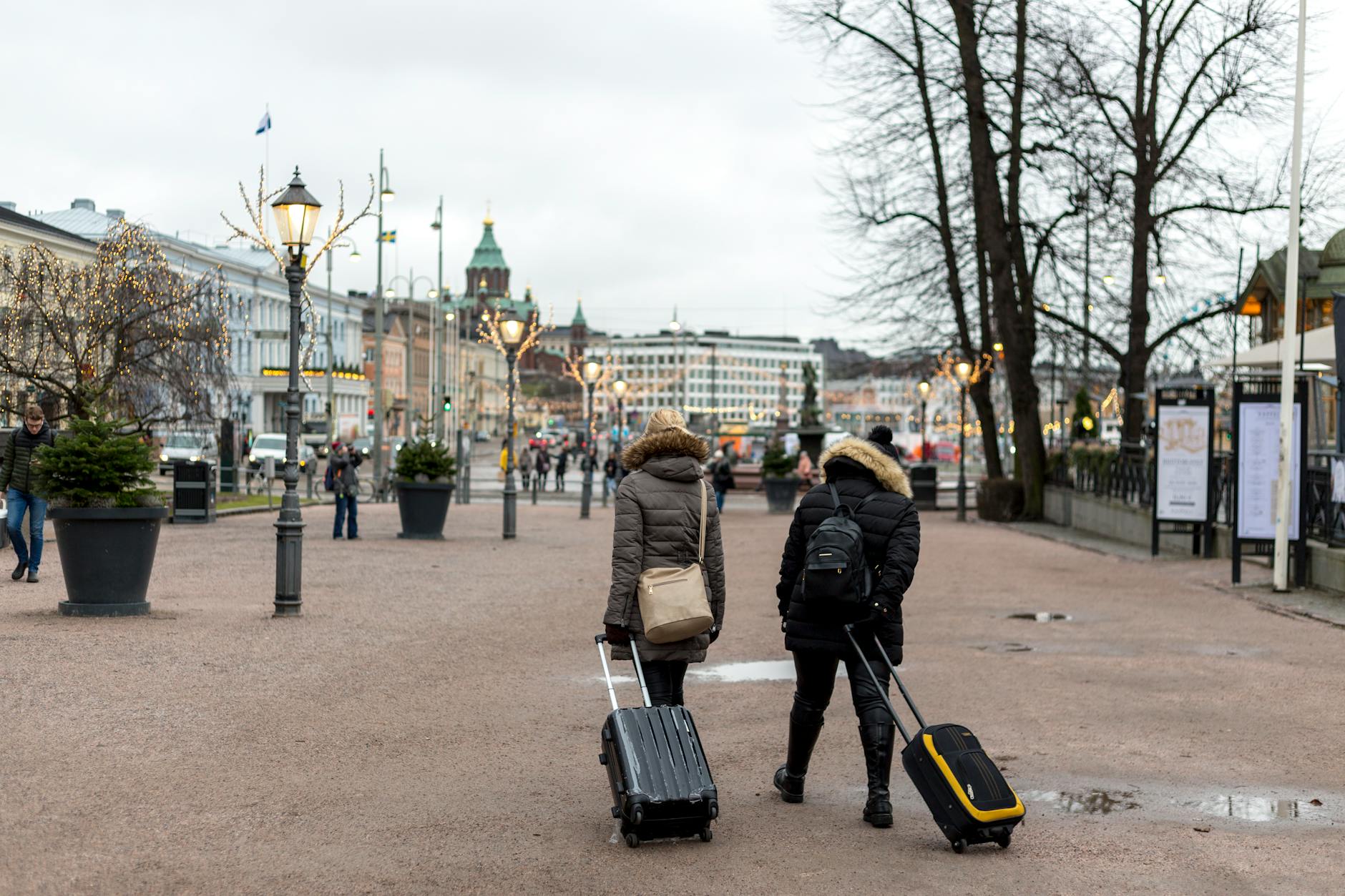 Travelers with luggage in Helsinki for arrival planning.