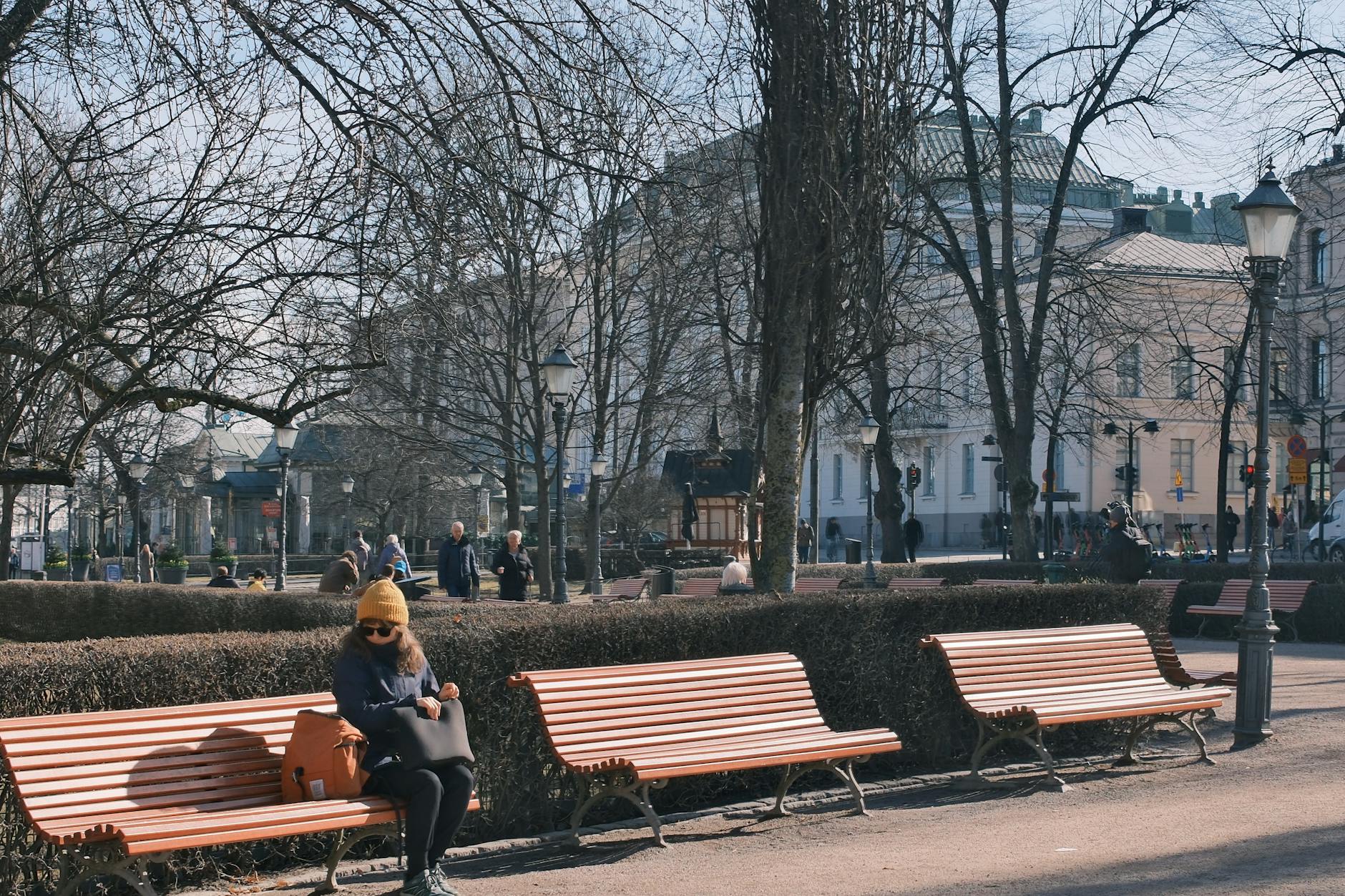 Woman sitting in a Helsinki winter park for district pacing.