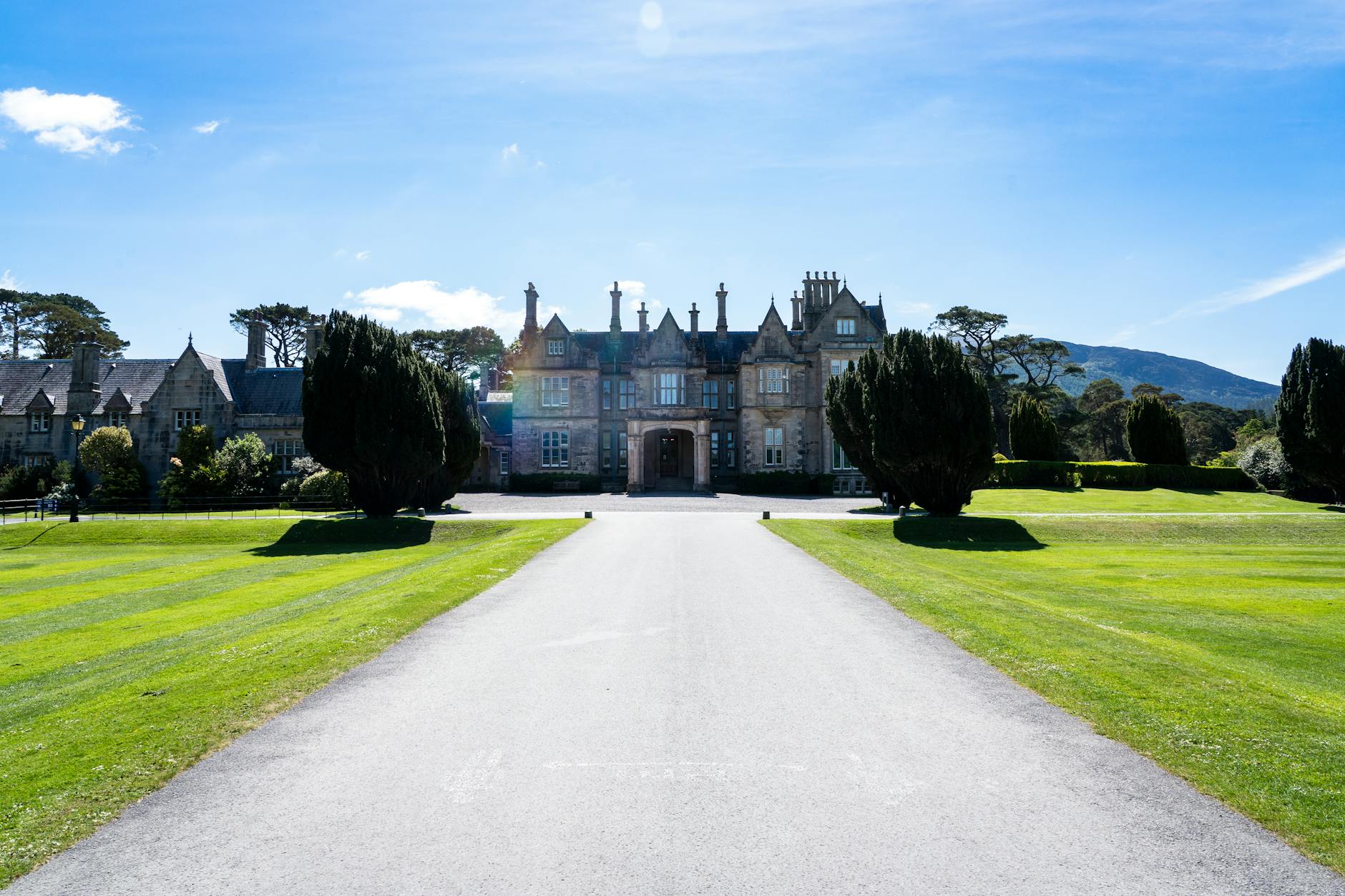 A stunning view of the historic Muckross House surrounded by lush gardens in Killarney, Ireland.