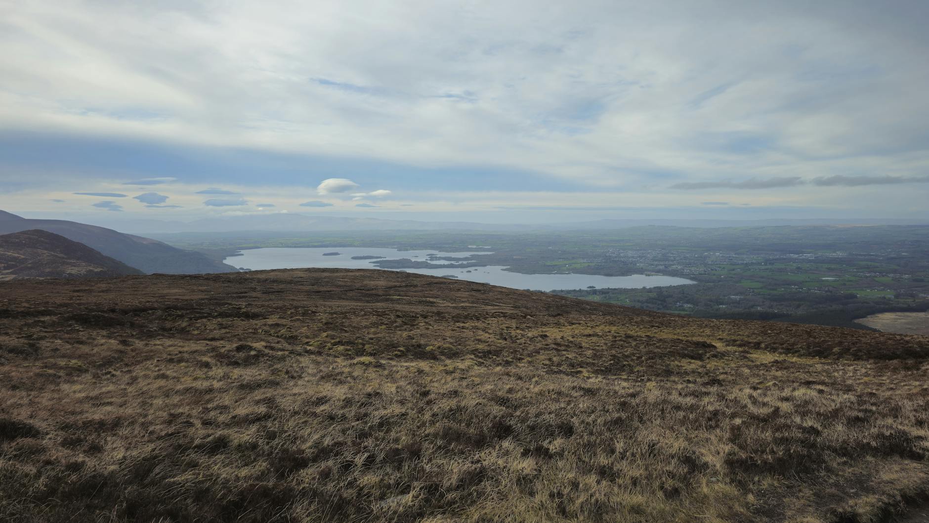 Stunning panoramic view of Killarney Lakes surrounded by lush green hills in Ireland.