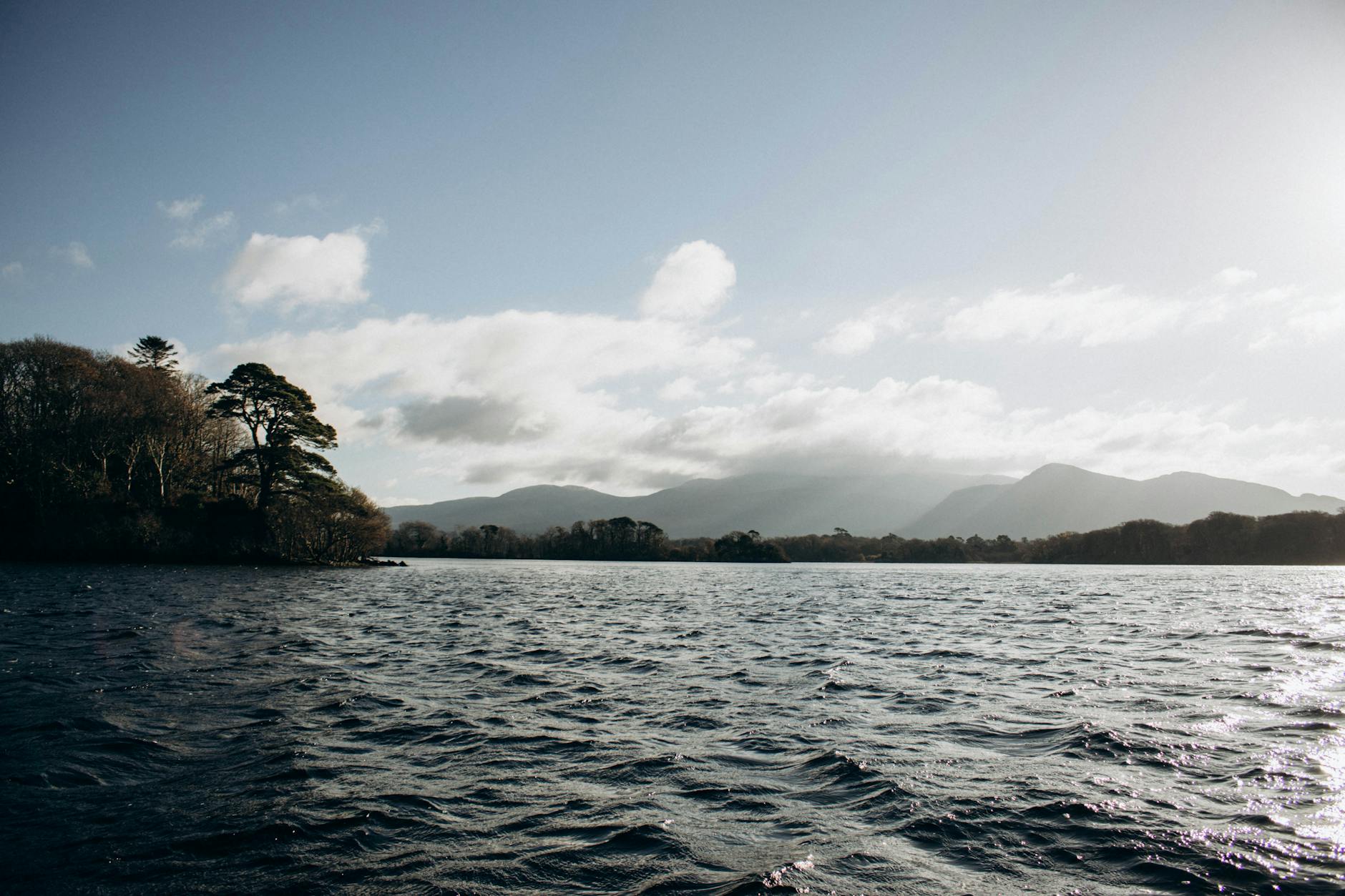 Peaceful lake view with green hills in Killarney, Ireland.