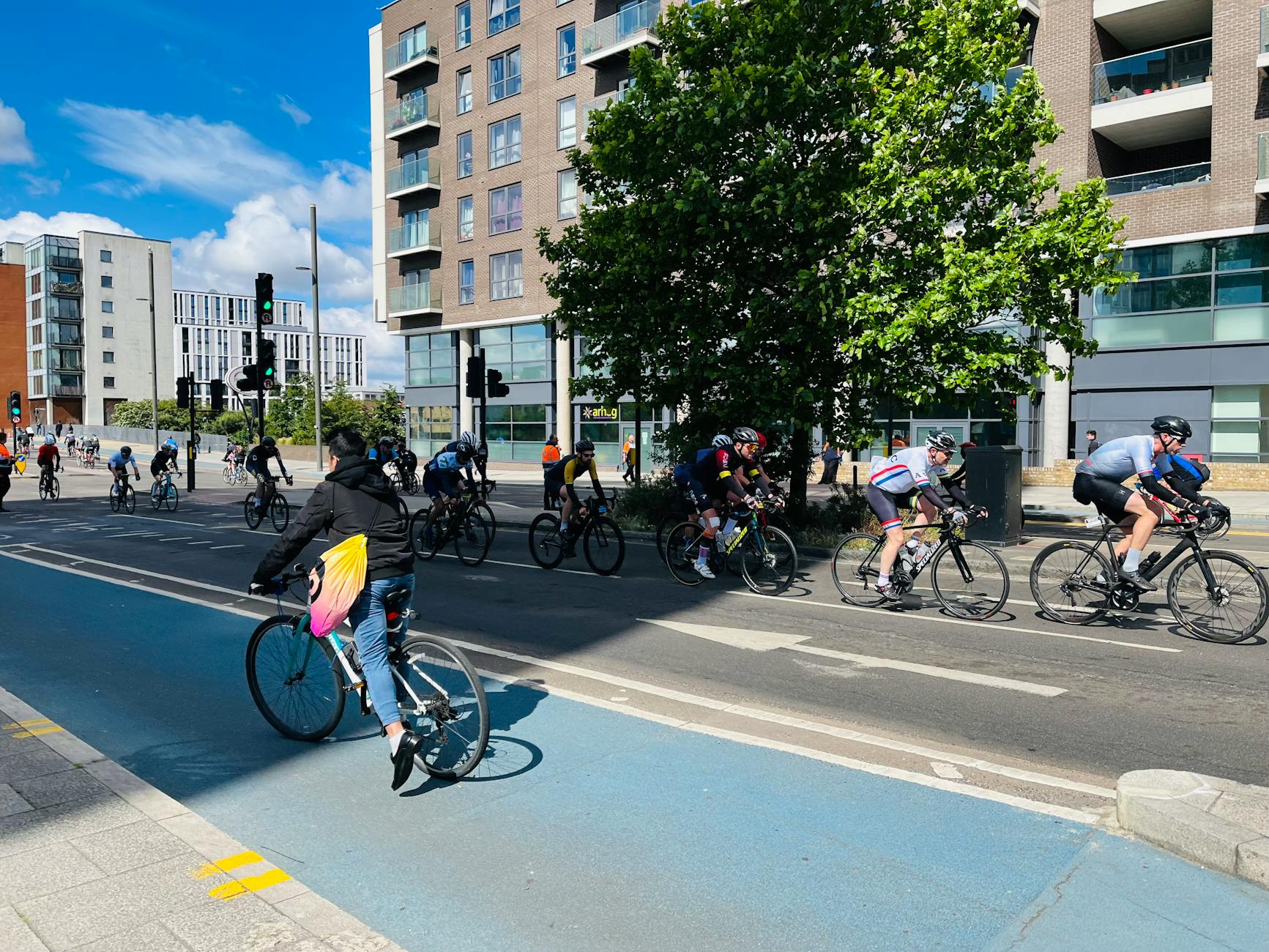 Cyclists riding through a modern urban street in Greater London