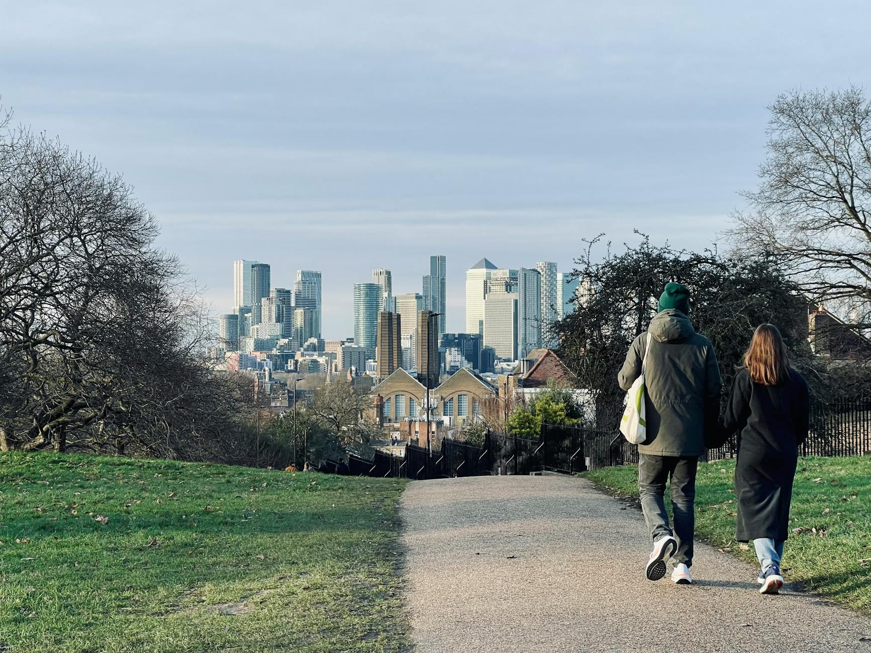Walkers in Greenwich Park overlooking London's skyline