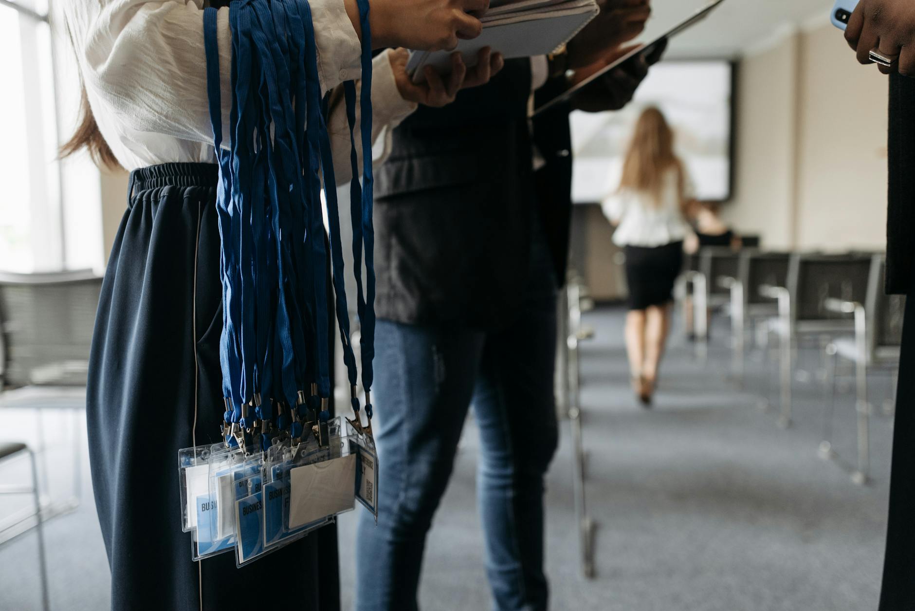 Conference attendees preparing with lanyards and badges