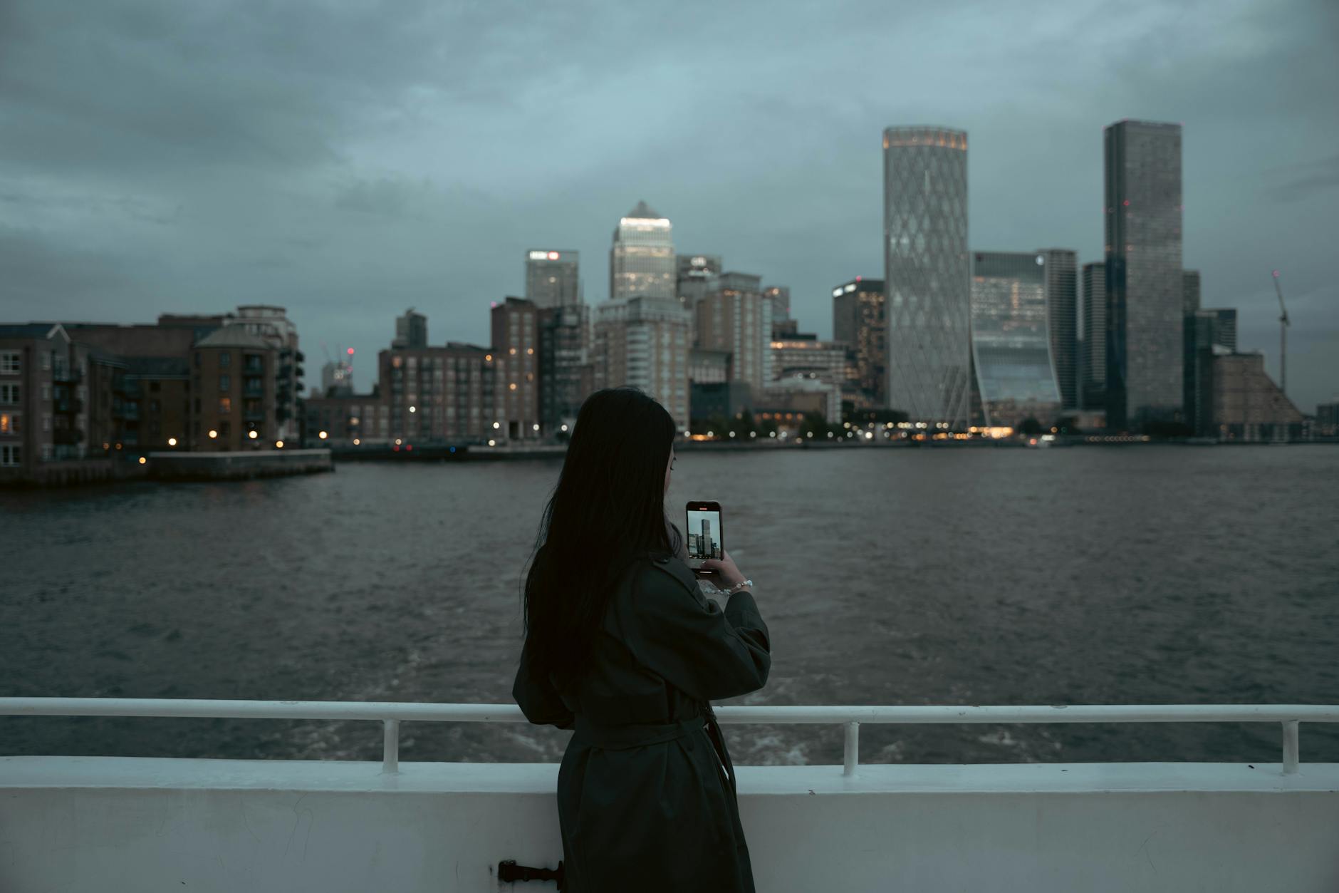 Person photographing the London skyline at dusk