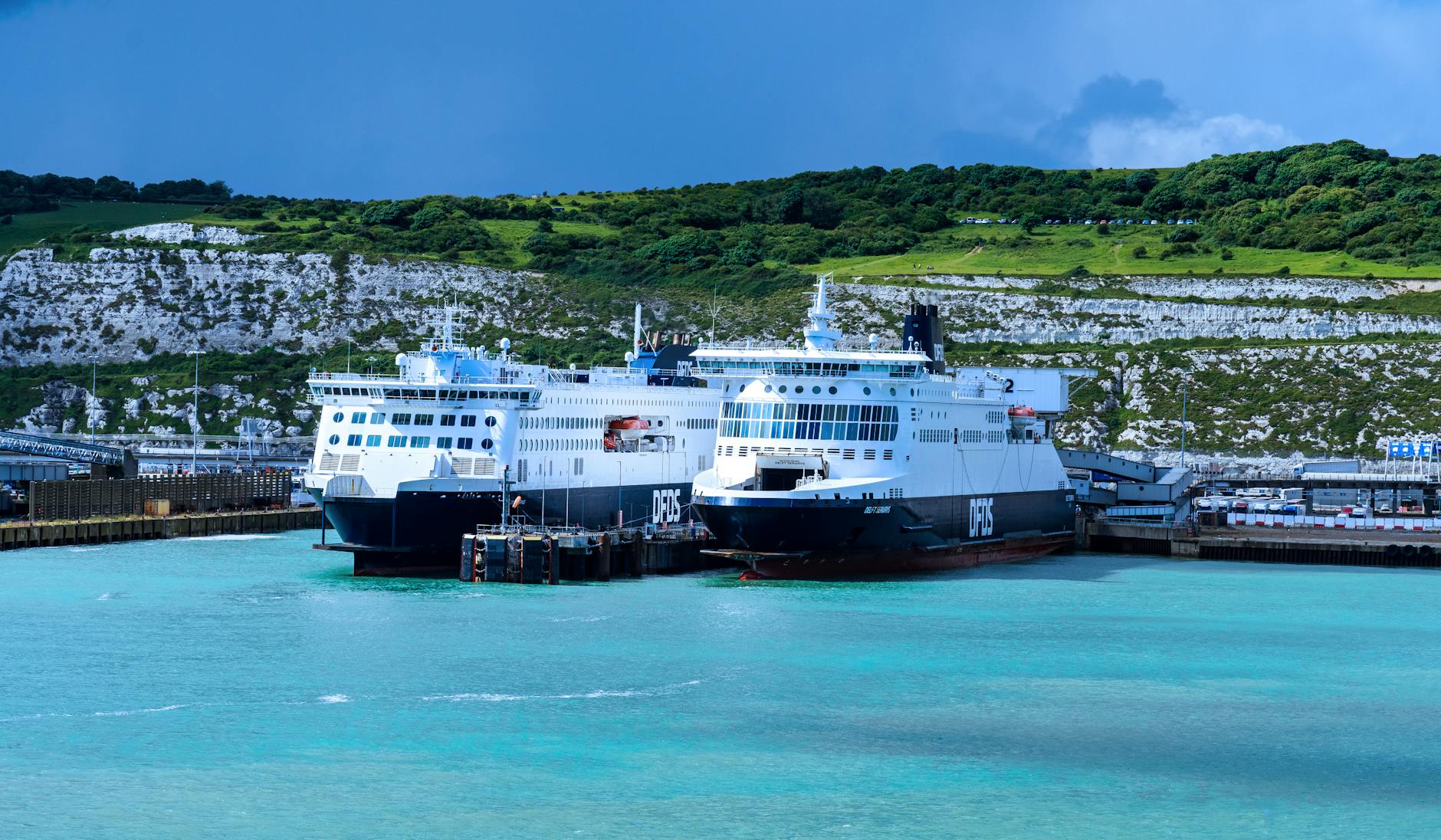 Ferries at Dover harbor with the white cliffs in the background