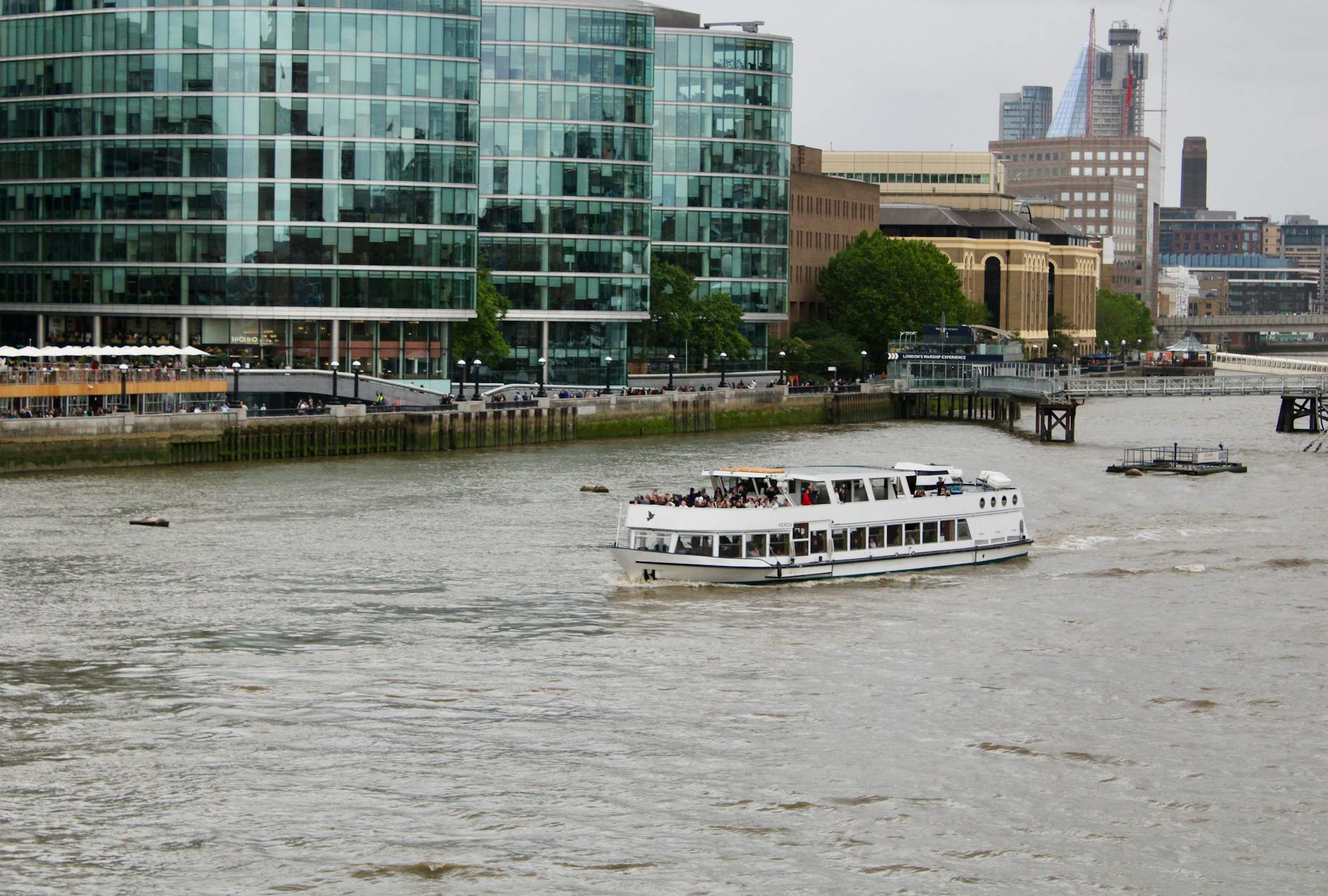 Sightseeing boat on the River Thames with London skyline
