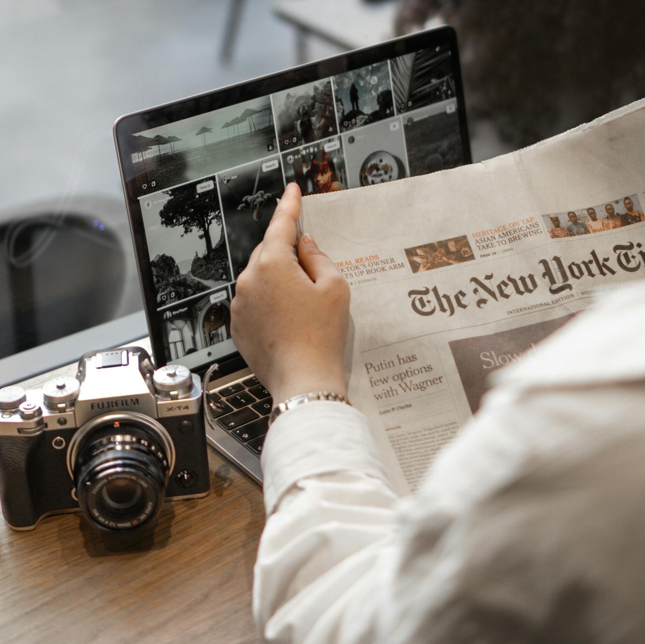 Newspaper, laptop, and camera arranged for journalism work