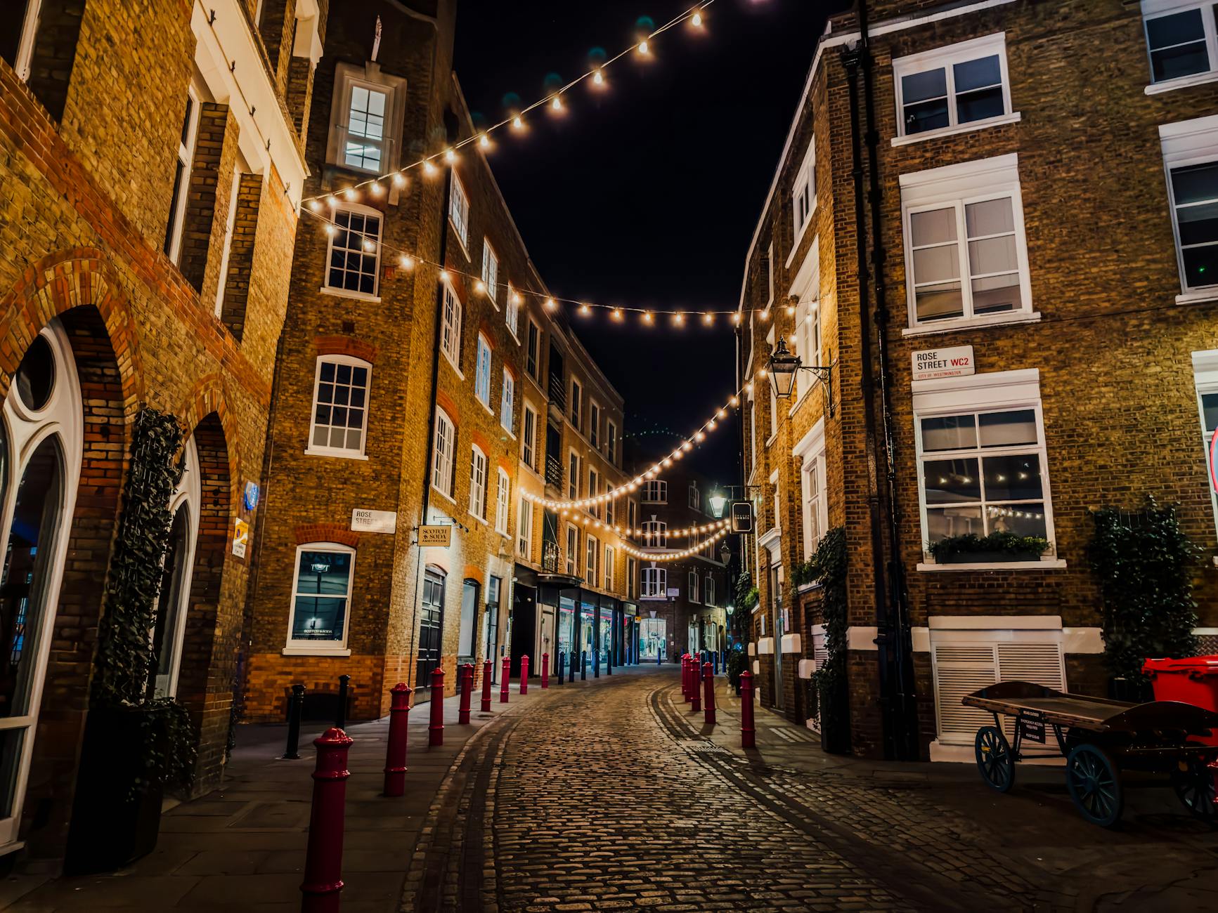 Illuminated cobblestone street in Soho at night