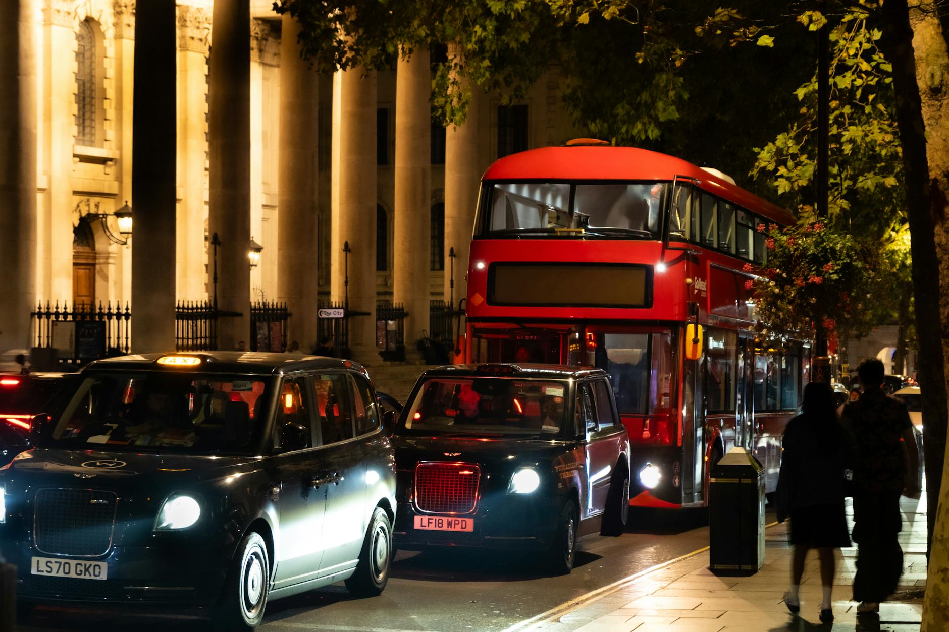 London night street with red bus and black cabs